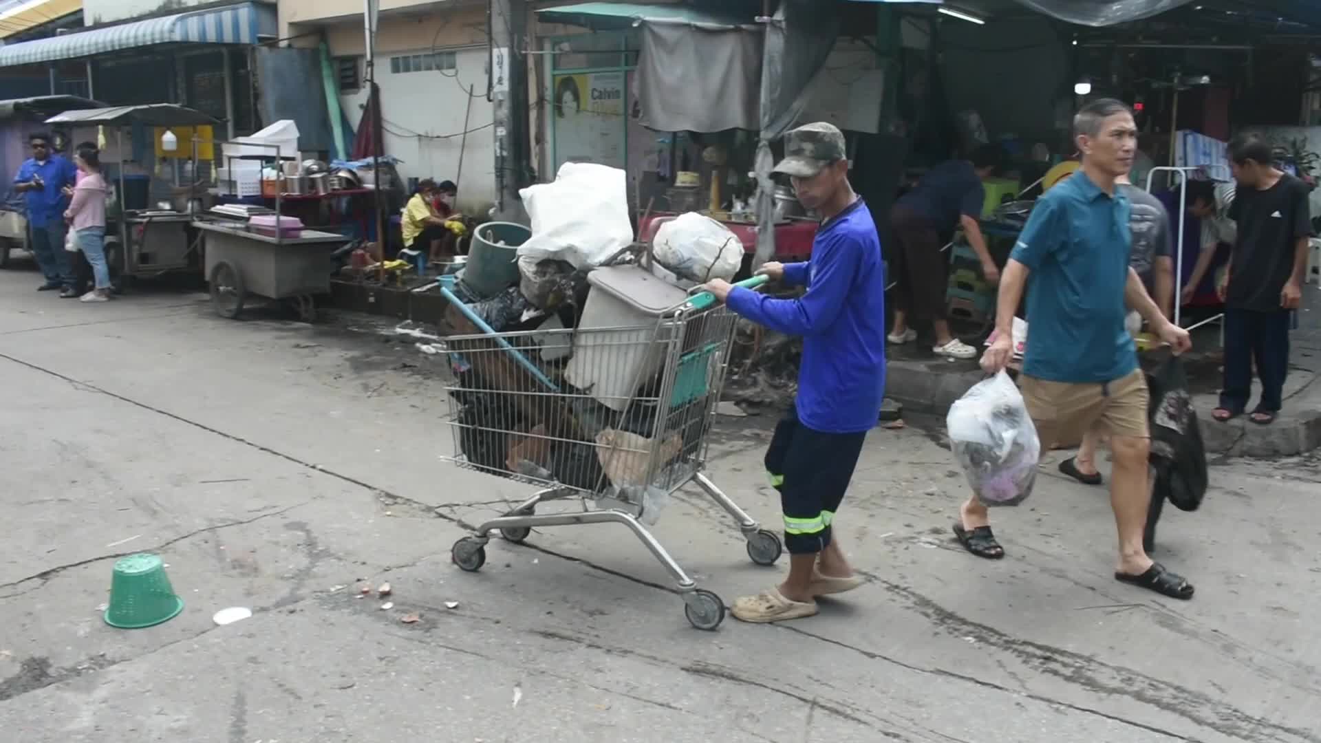 Volunteers and workers clean pile of rubbish.