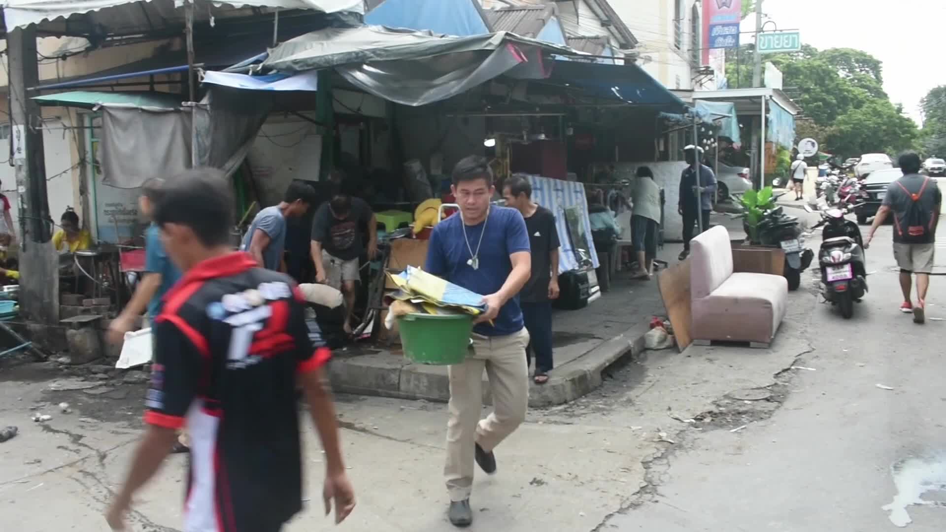 Volunteers and workers clean pile of rubbish.