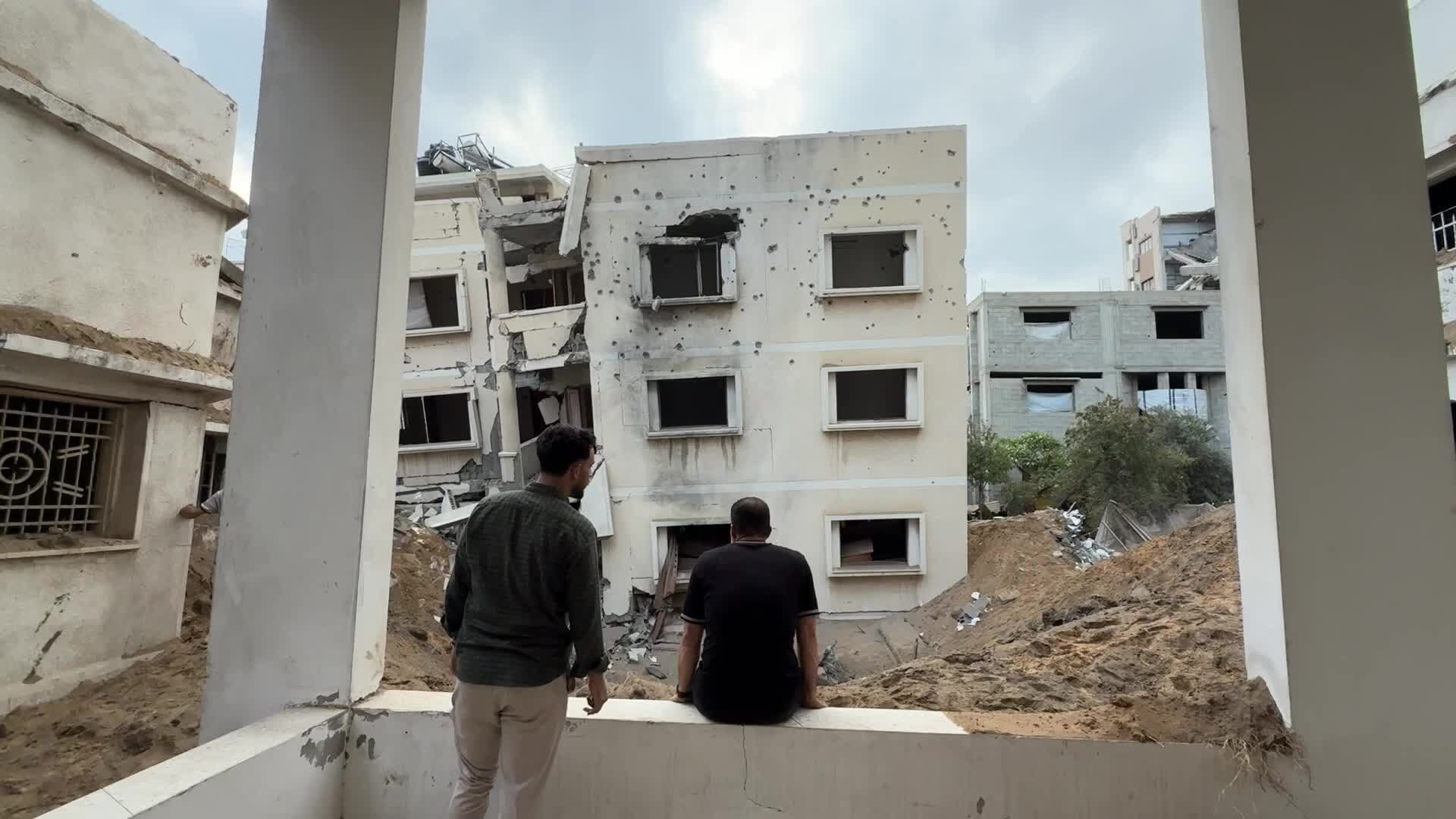 A Palestinian inspects the site of a house targeted by Israeli airstrikes after the Israeli military warned residents