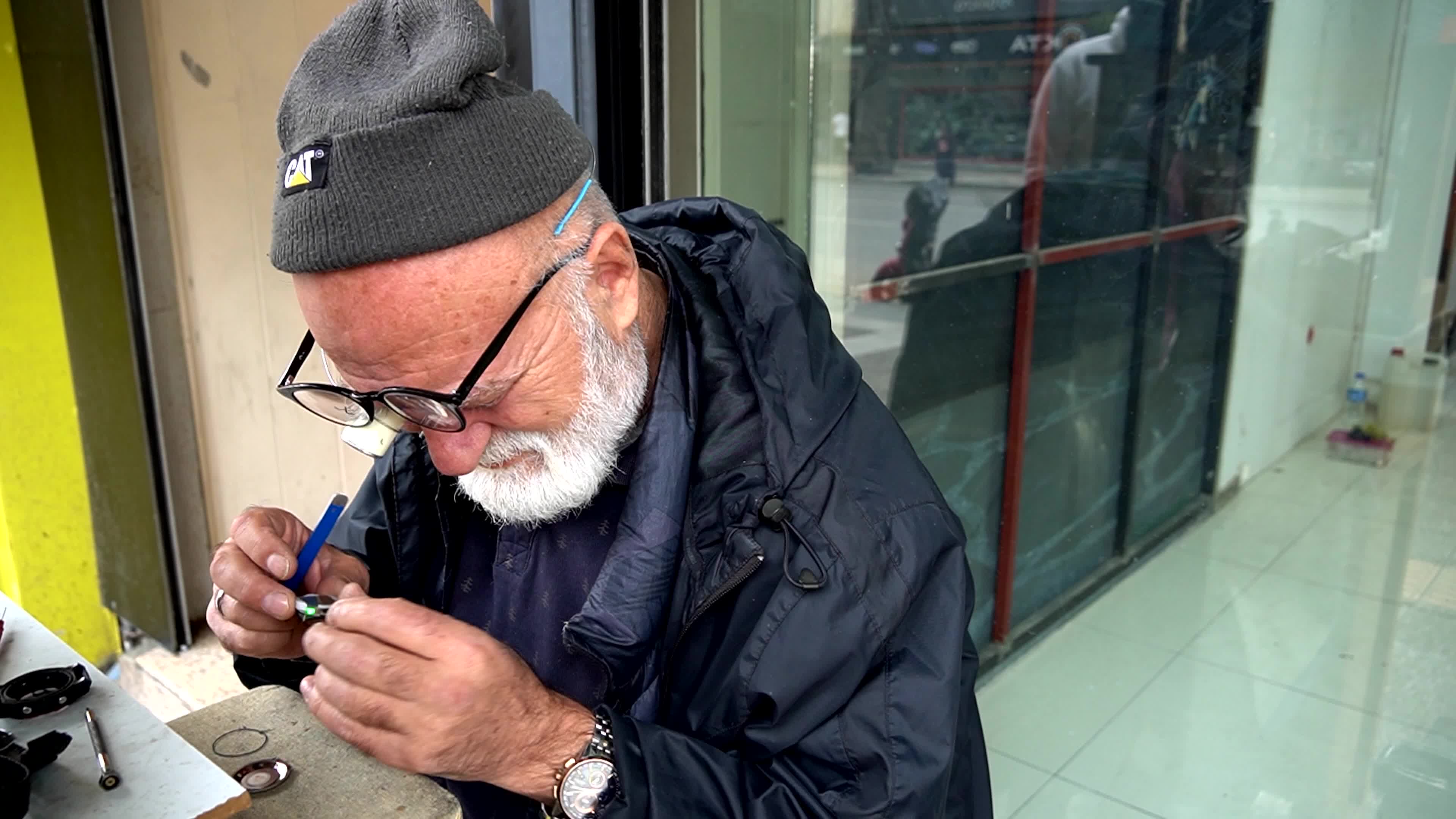 Portrait of a lifelong artisan repairing an old watch