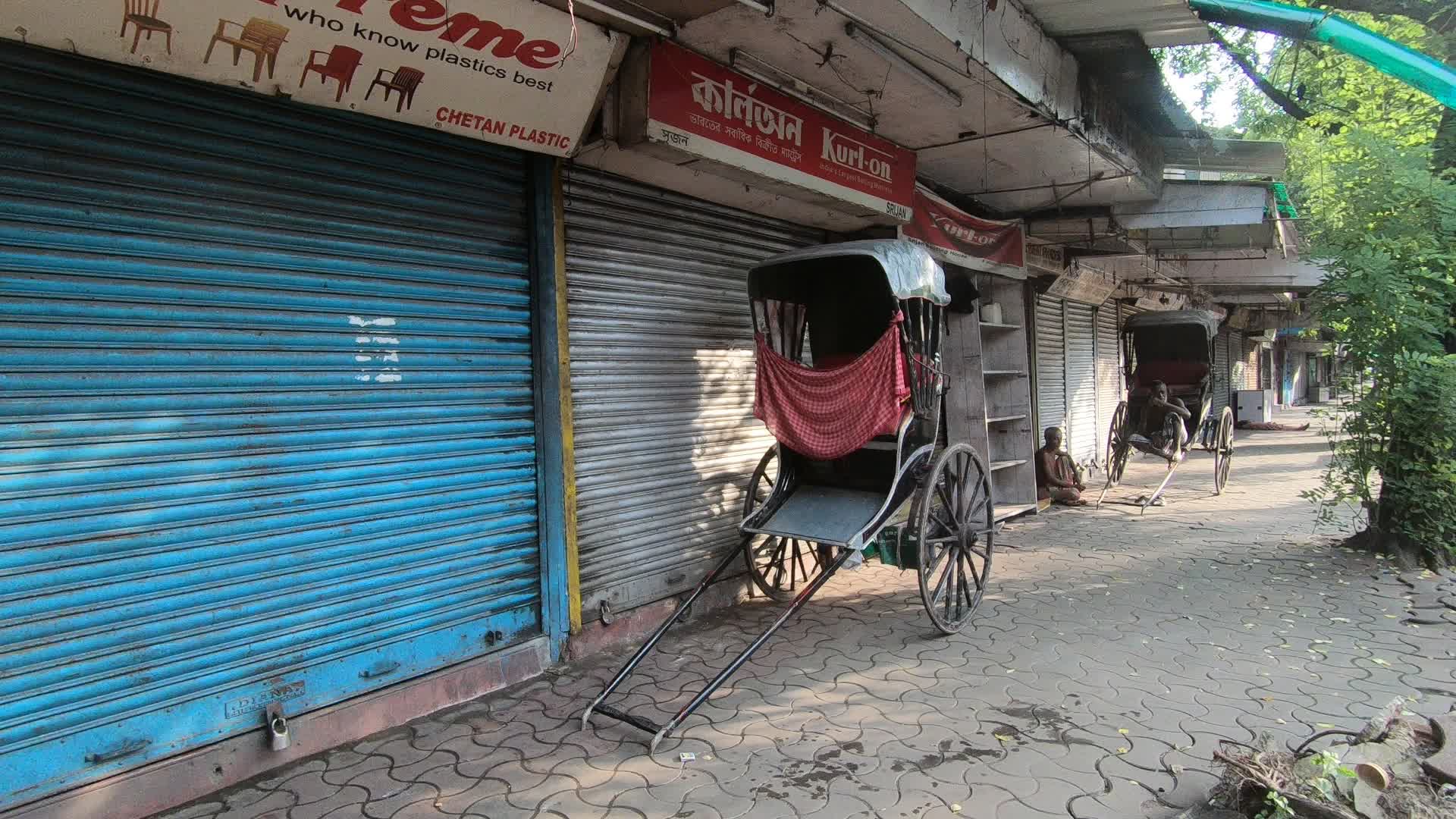 Hand rickshaw puller is sitting on his rickshaw on a deserted road in Kolkata