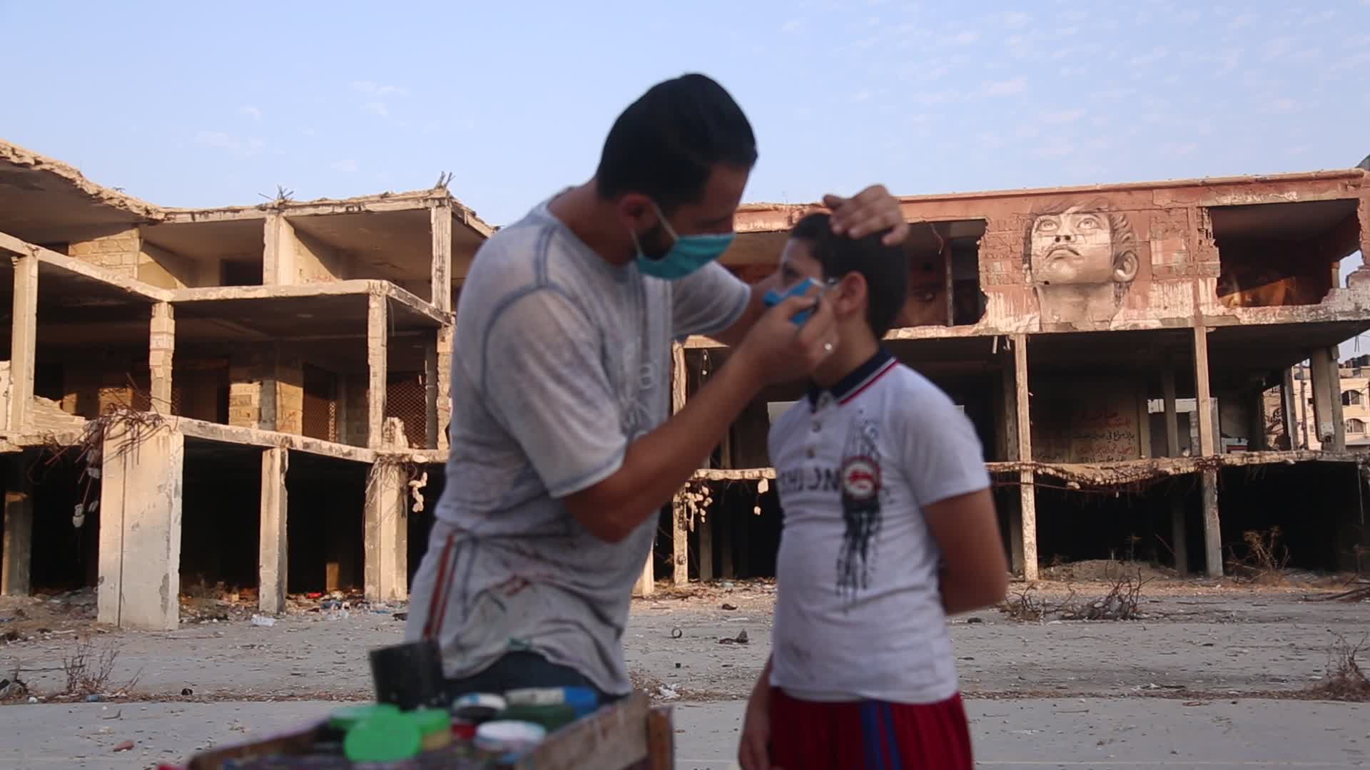 Palestinian artist draws a mask to childs in Gaza