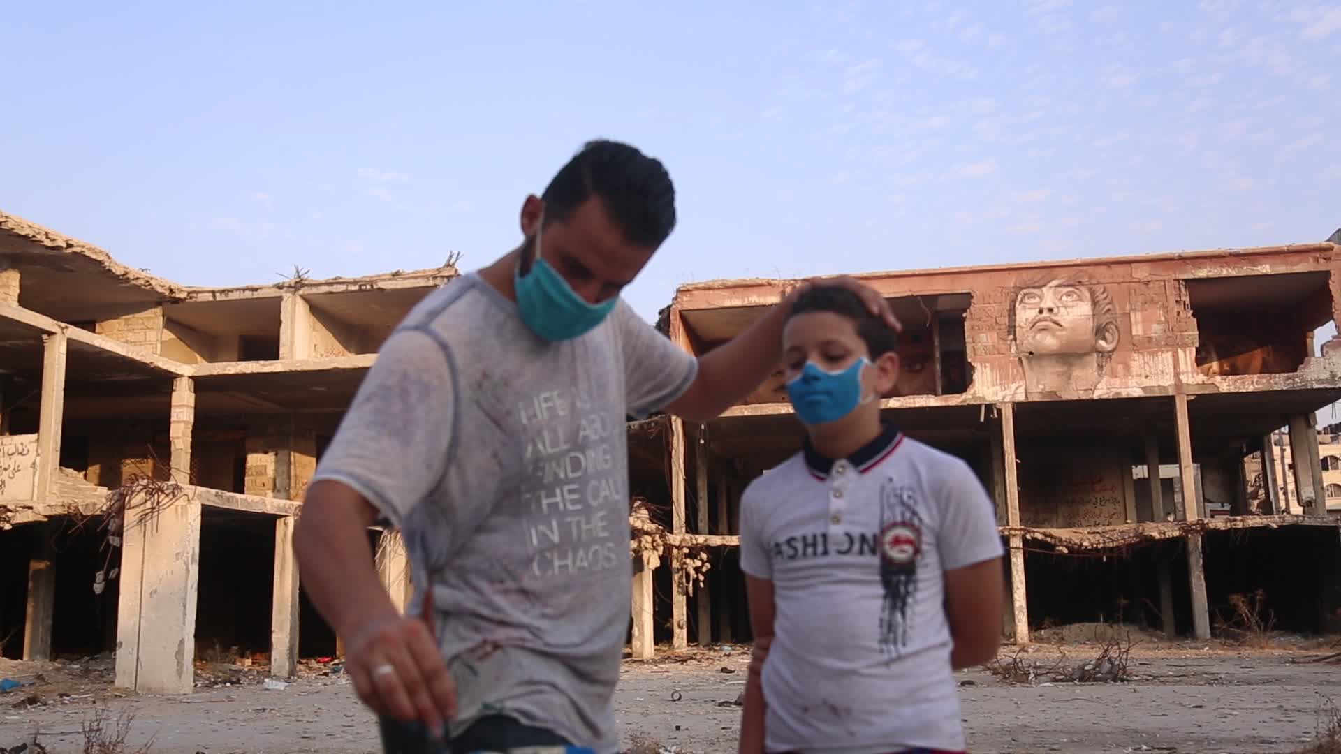 Palestinian artist draws a mask to childs in Gaza