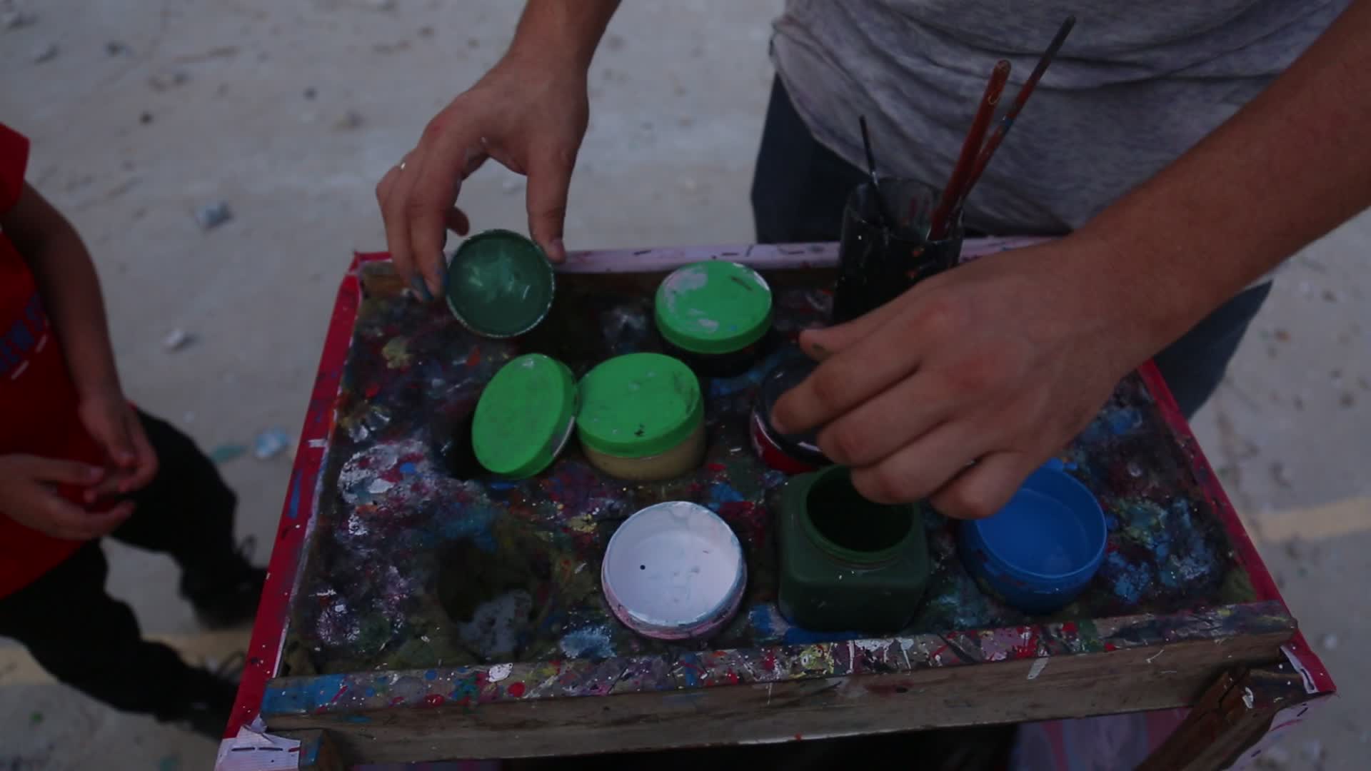 Palestinian artist draws a mask to childs in Gaza