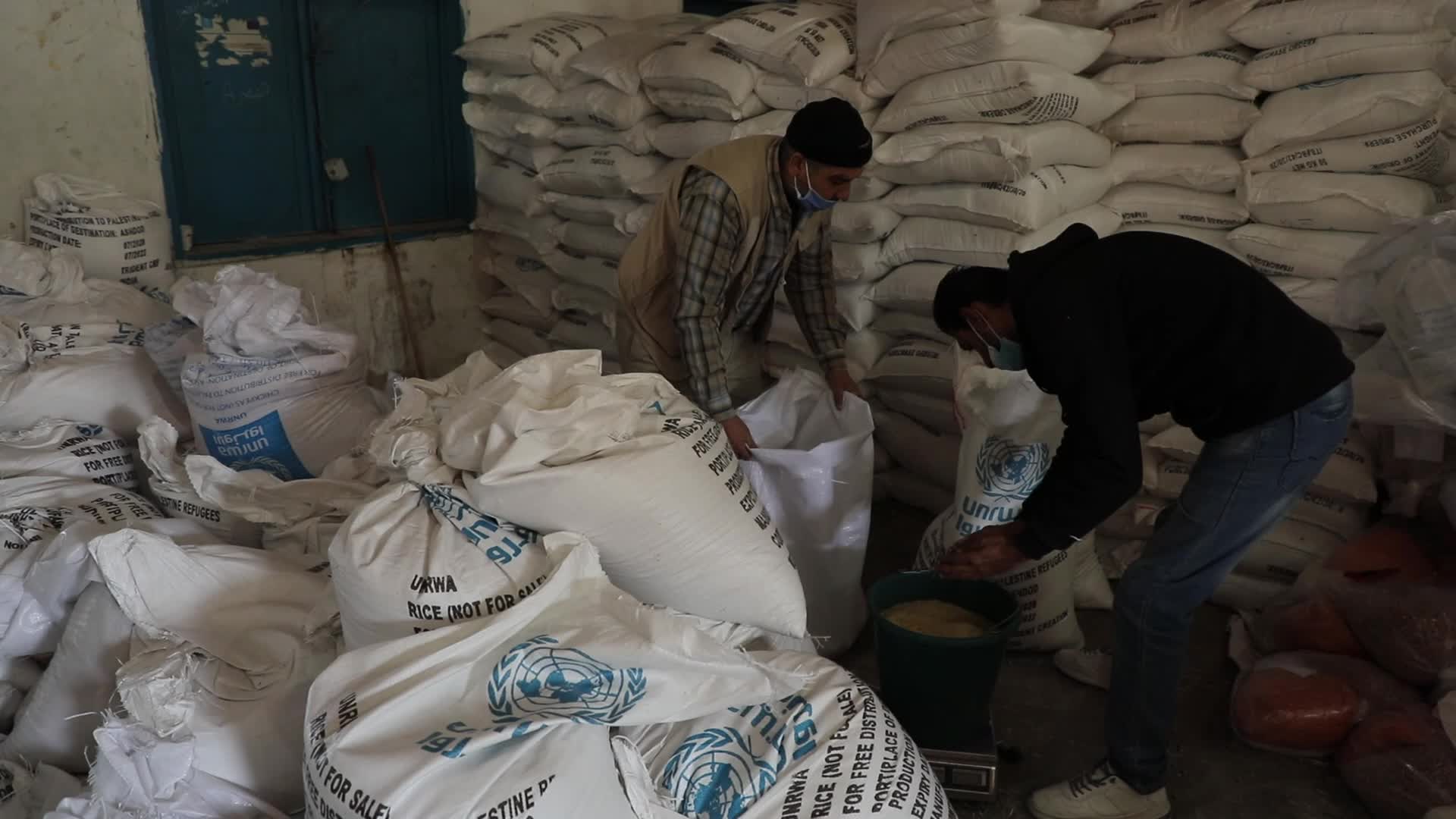 Palestinian refugees receive aid distributed by UNRWA in Gaza