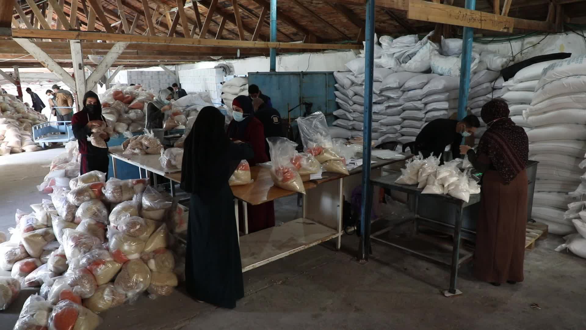 Palestinian refugees receive aid distributed by UNRWA in Gaza