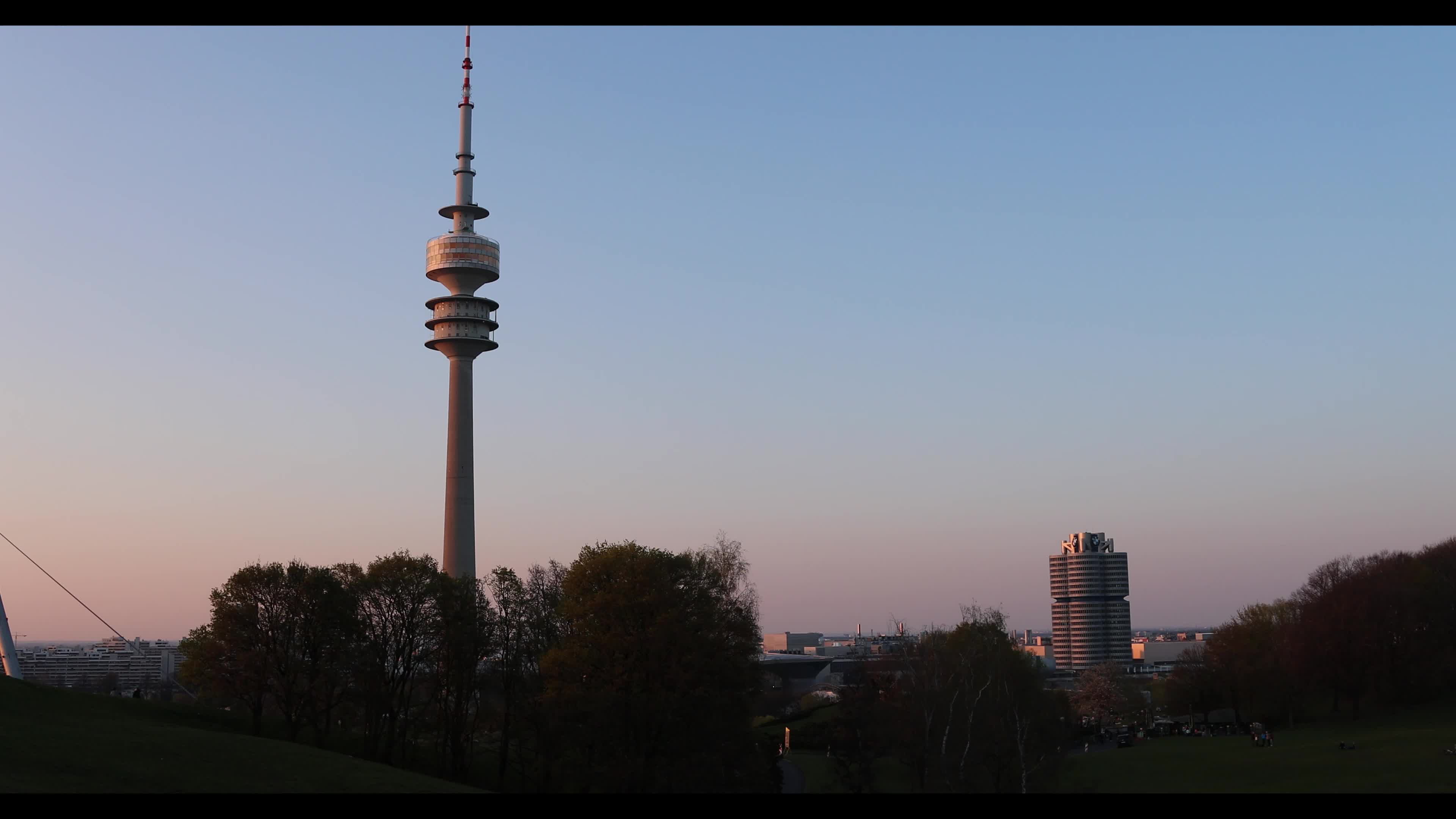 People enjoy the sunset in the Olympic park in Munich
