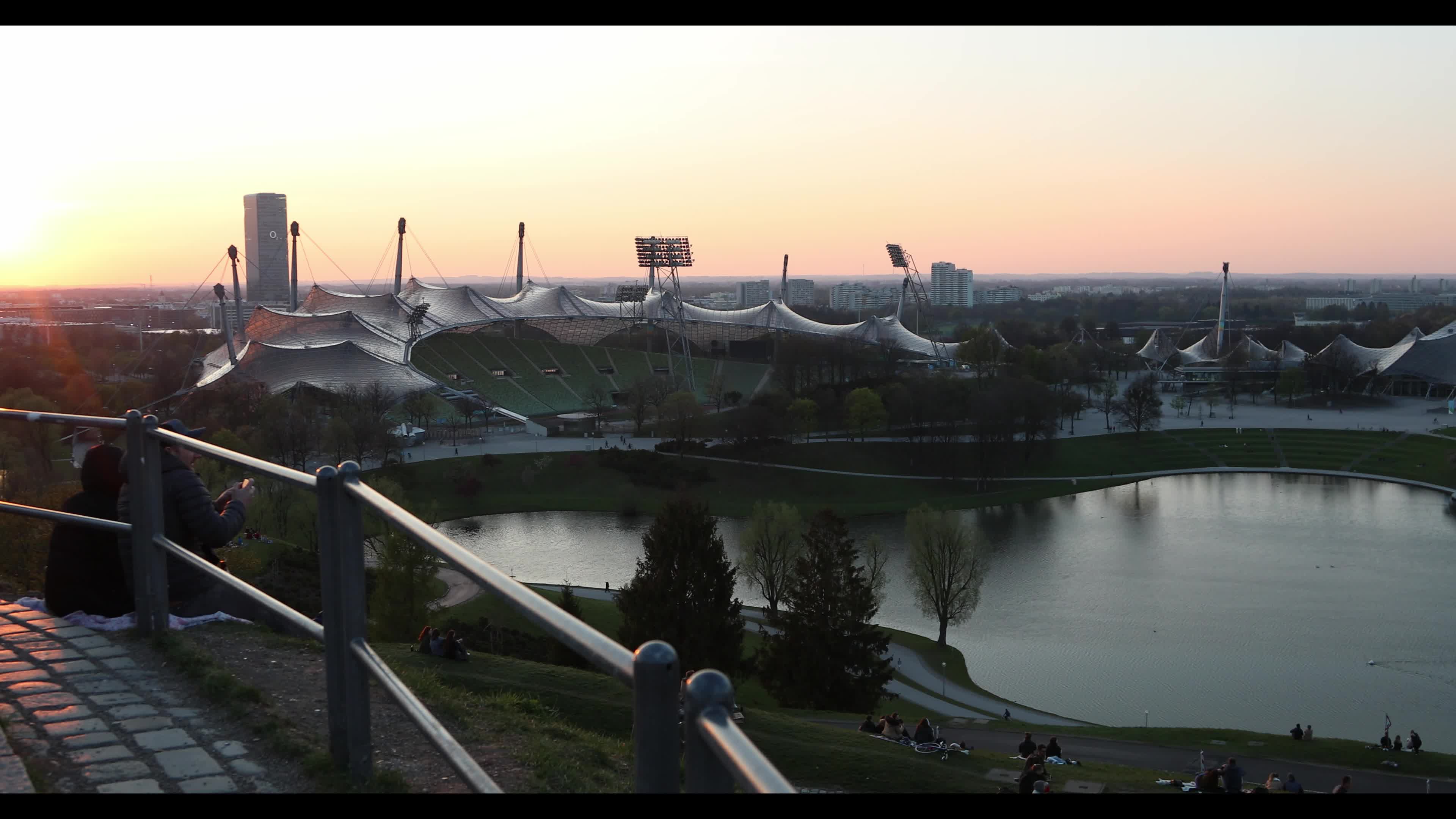 People enjoy the sunset in the Olympic park in Munich