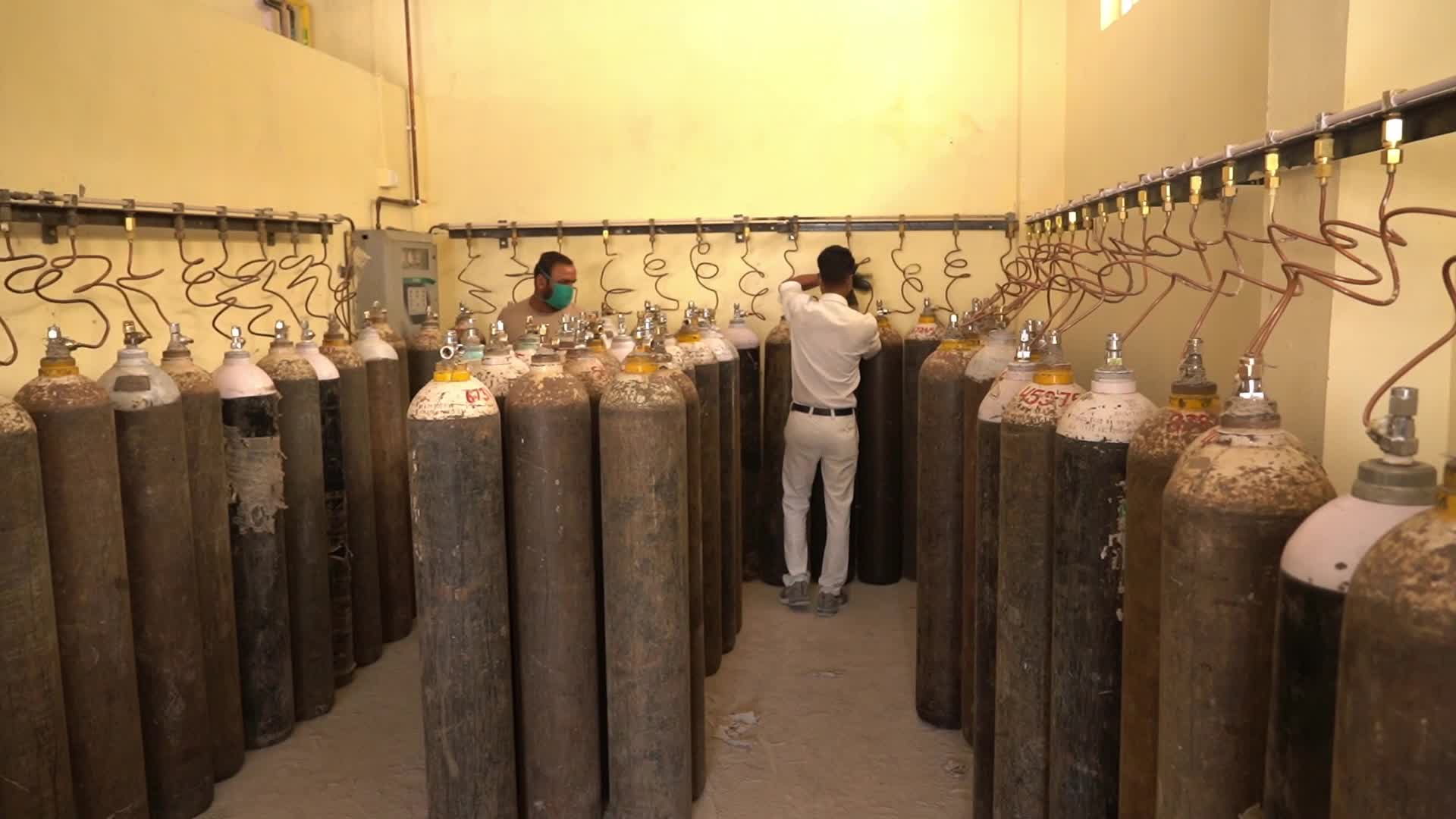 Workers are seen sorting oxygen cylinders that are being used for Covid-19 coronavirus patients