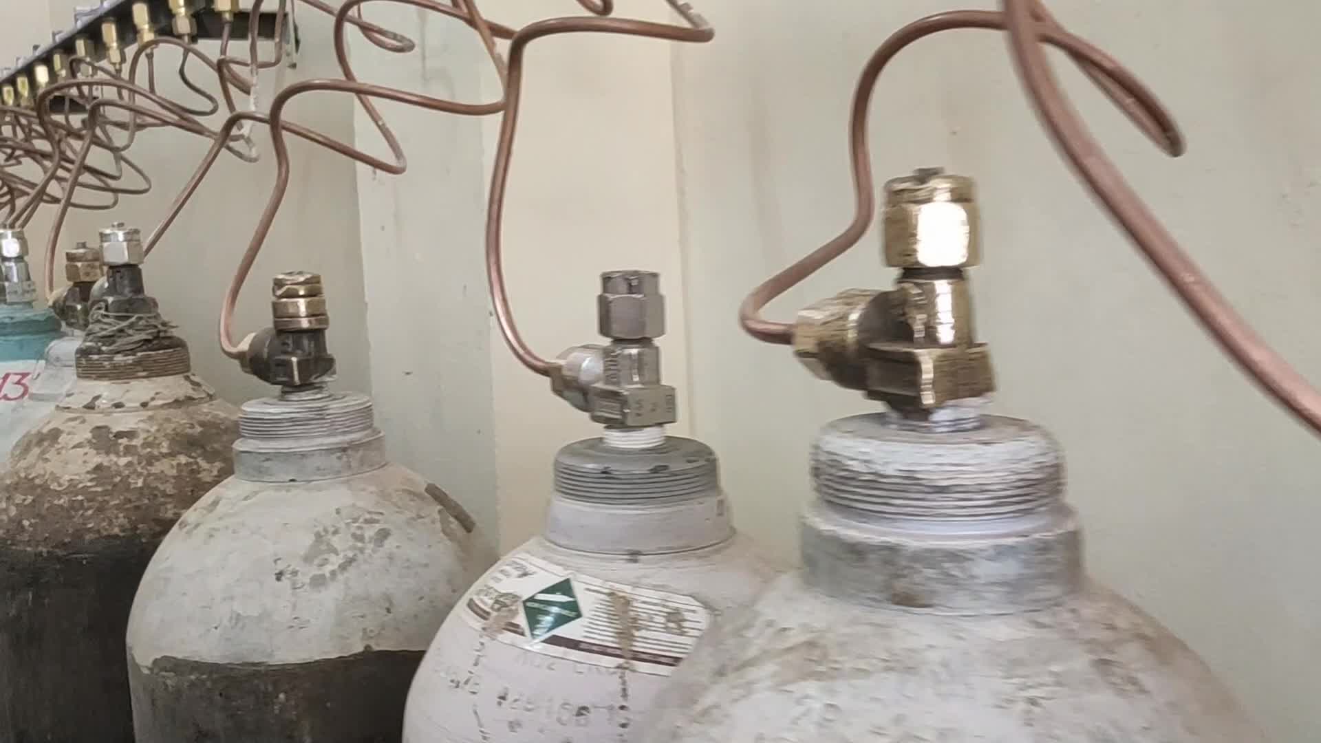 Workers are seen sorting oxygen cylinders that are being used for Covid-19 coronavirus patients