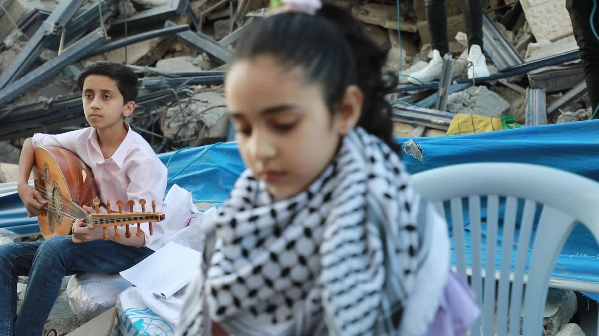 Singers perform on rubbles of a building in Gaza