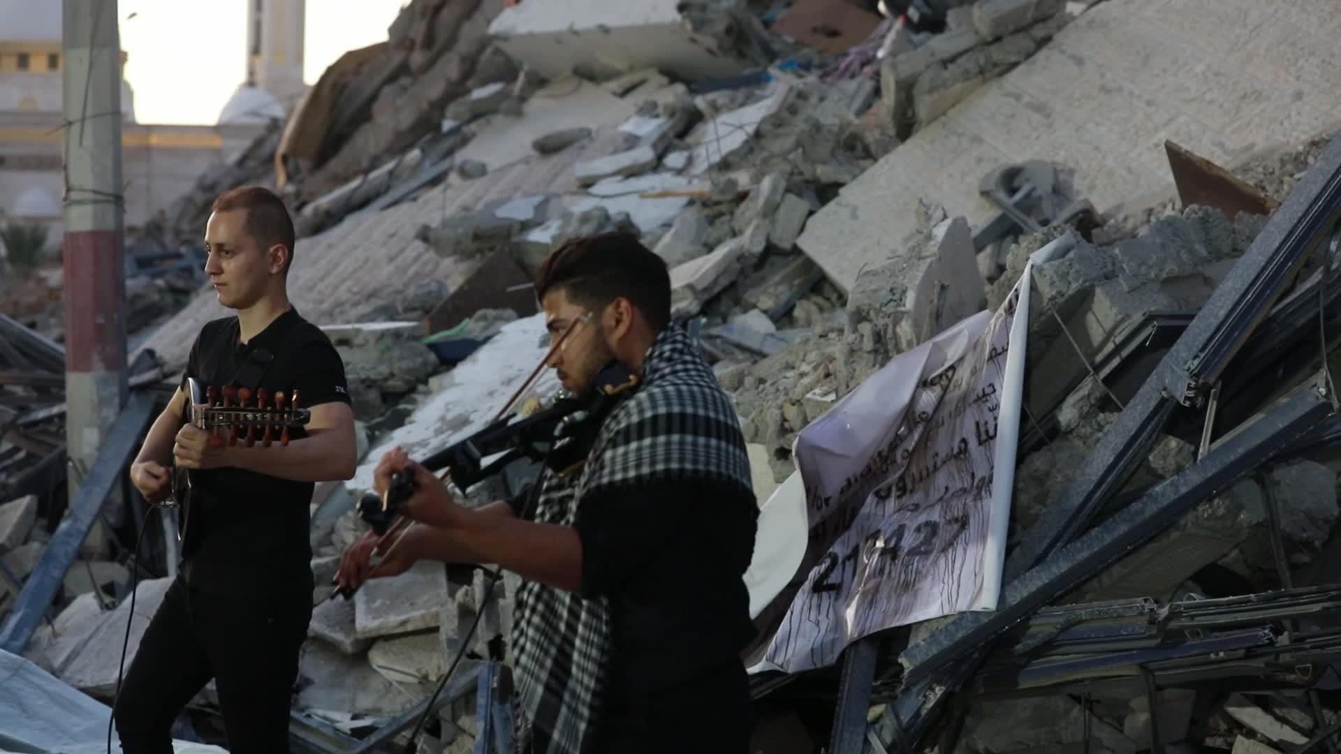 Singers perform on rubbles of a building in Gaza