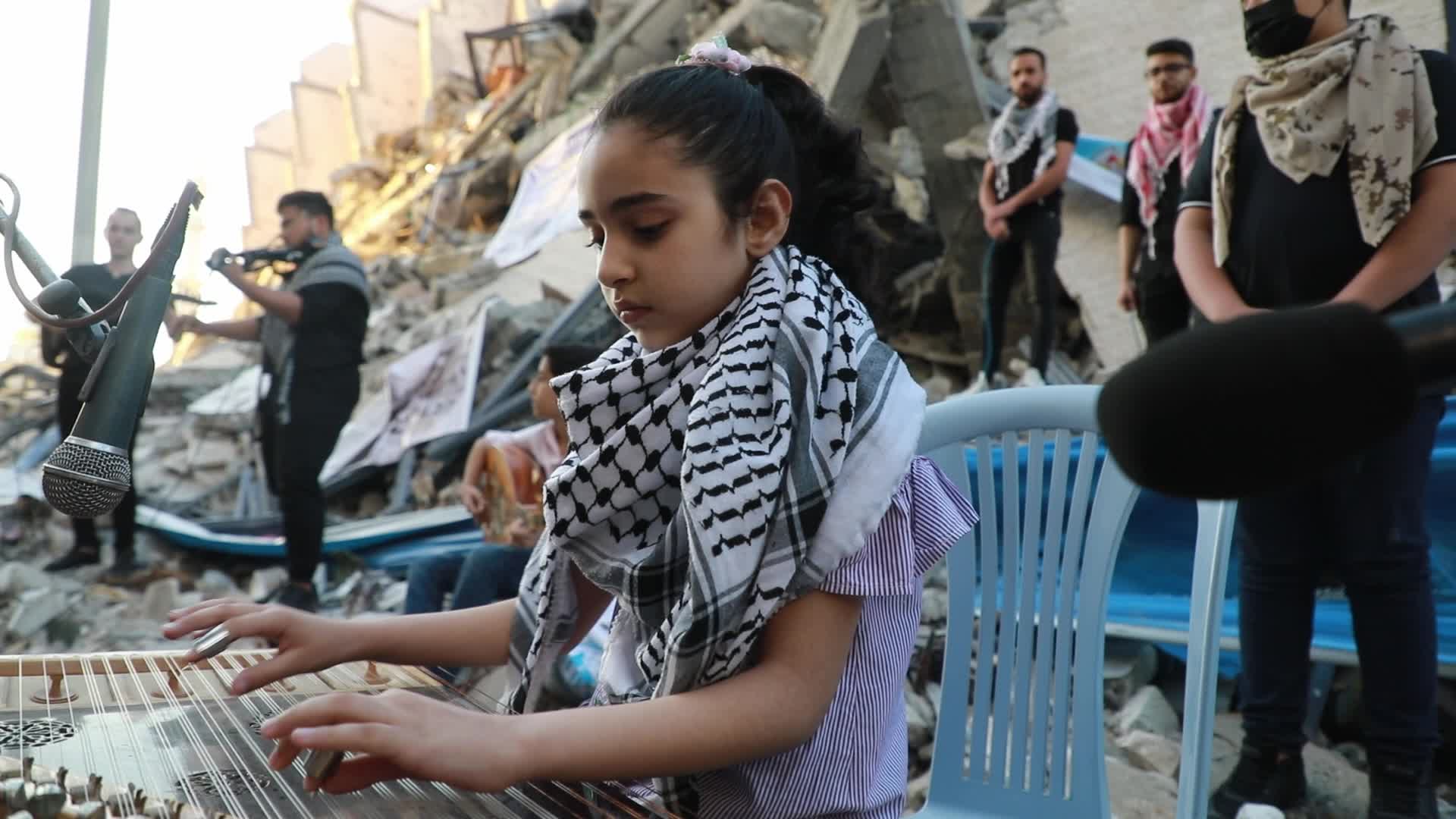 Singers perform on rubbles of a building in Gaza
