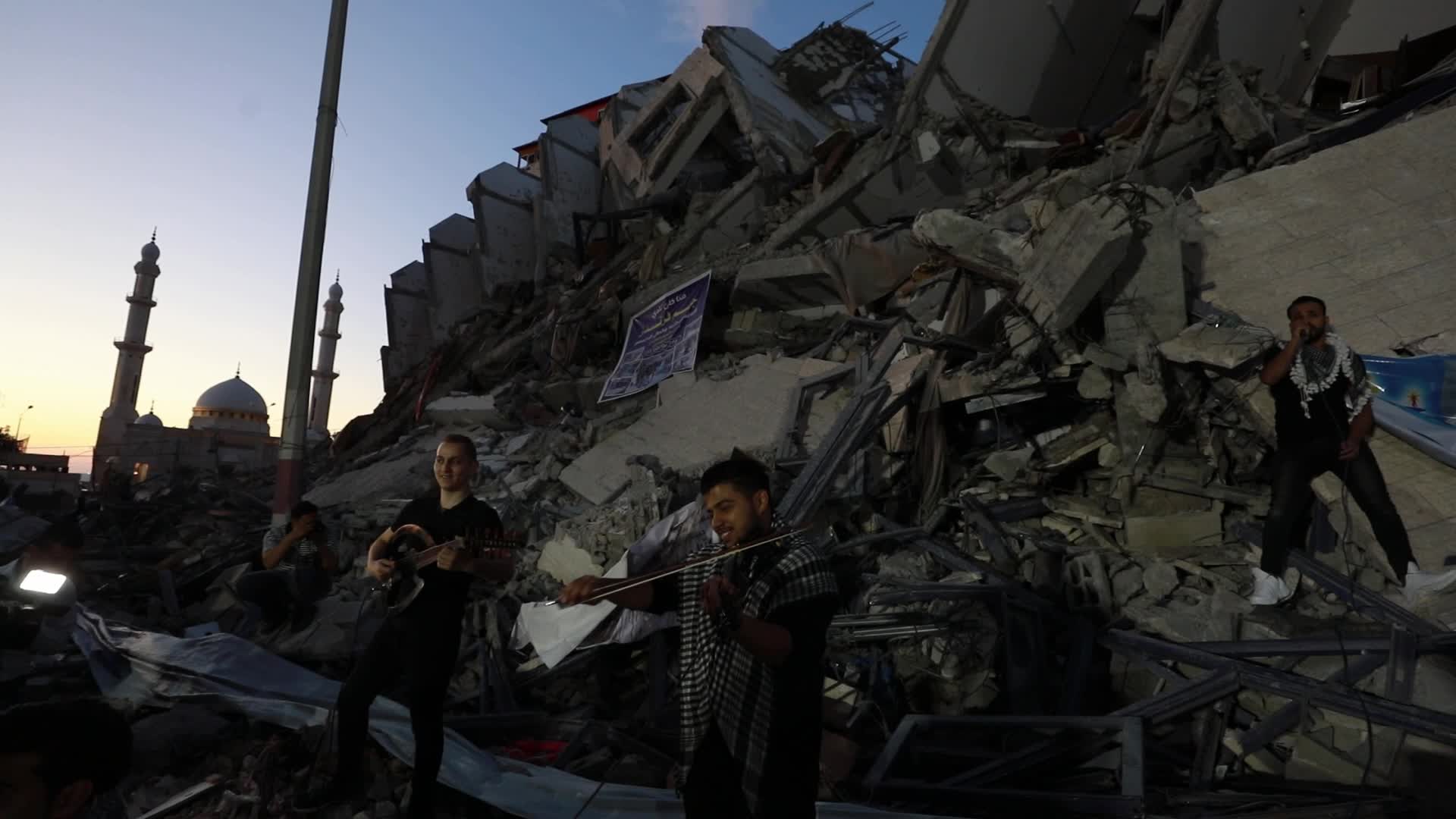 Singers perform on rubbles of a building in Gaza