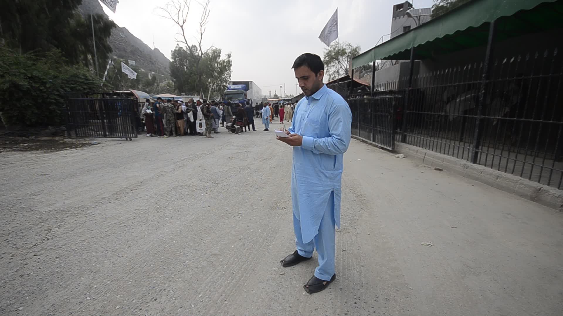 Taliban fighters and Pakistani soldiers guard the Torkham crossing side-by-side in Peshawar