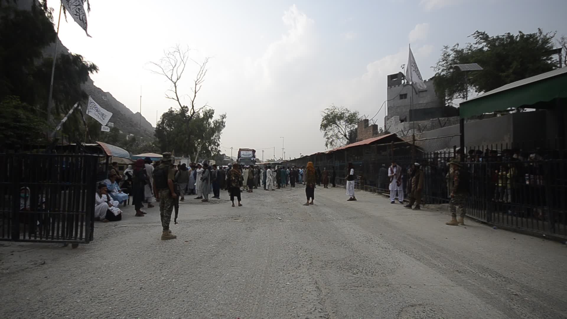 Taliban fighters and Pakistani soldiers guard the Torkham crossing side-by-side in Peshawar