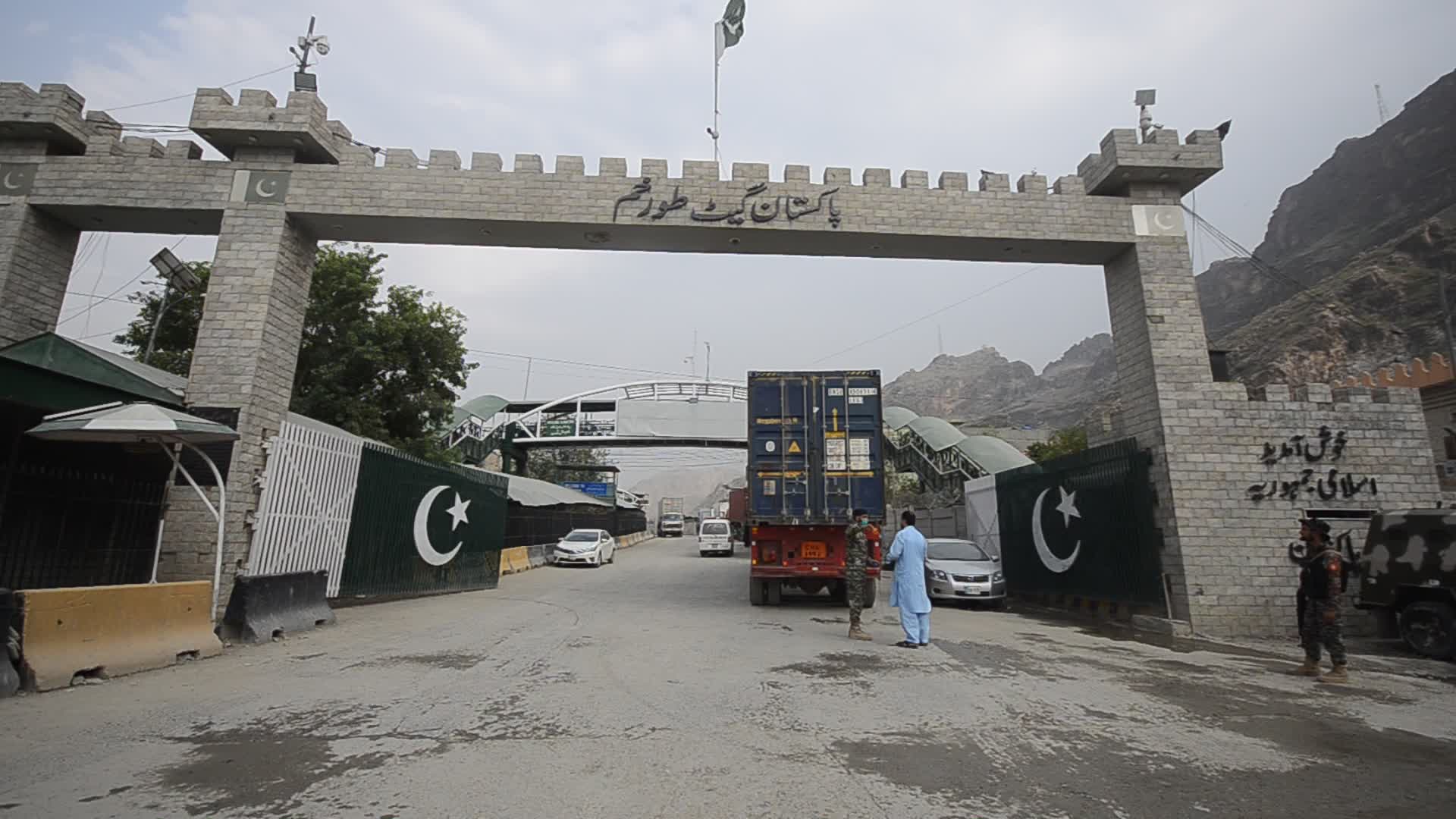 Taliban fighters and Pakistani soldiers guard the Torkham crossing side-by-side in Peshawar