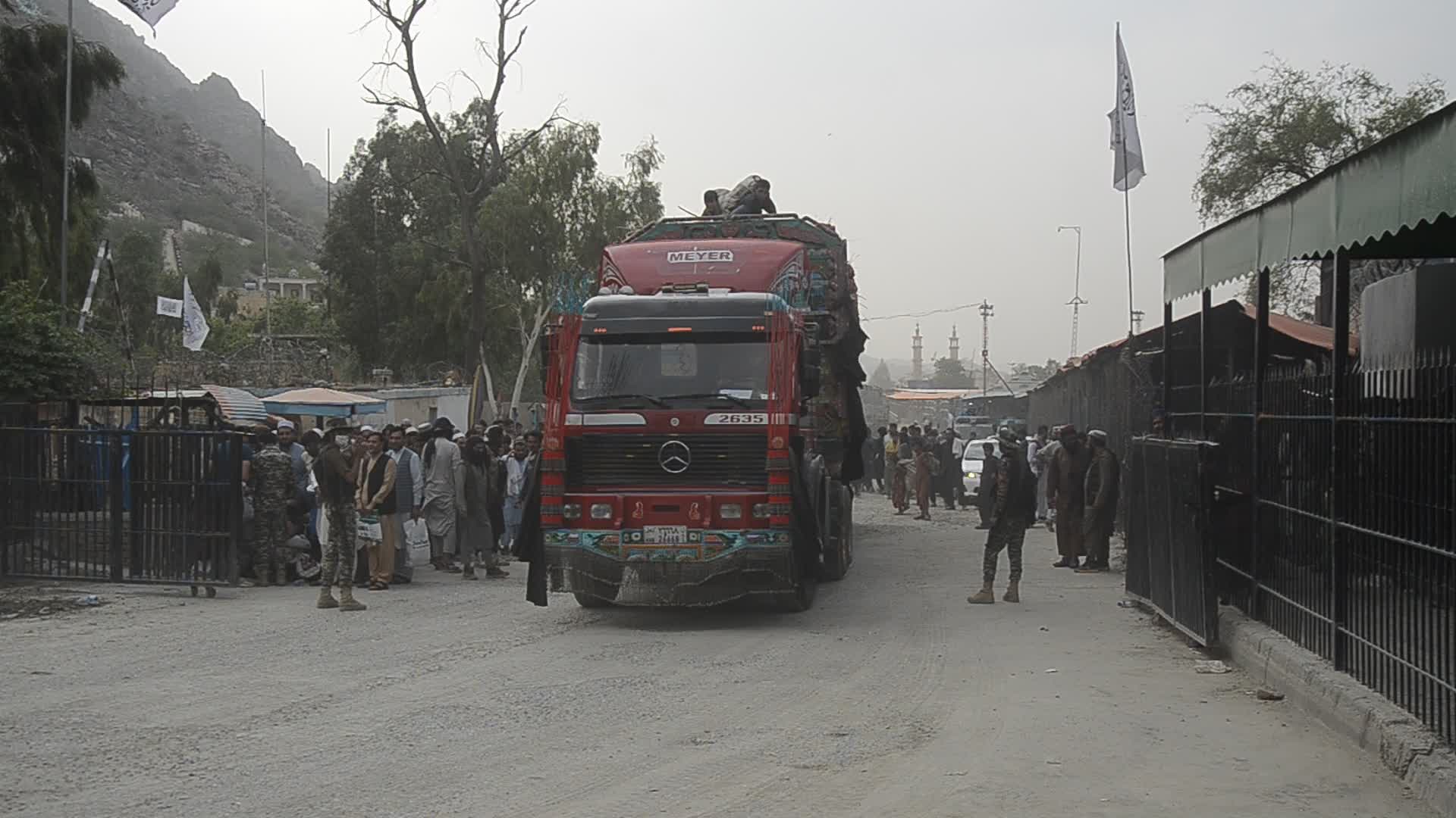 Taliban fighters and Pakistani soldiers guard the Torkham crossing side-by-side in Peshawar