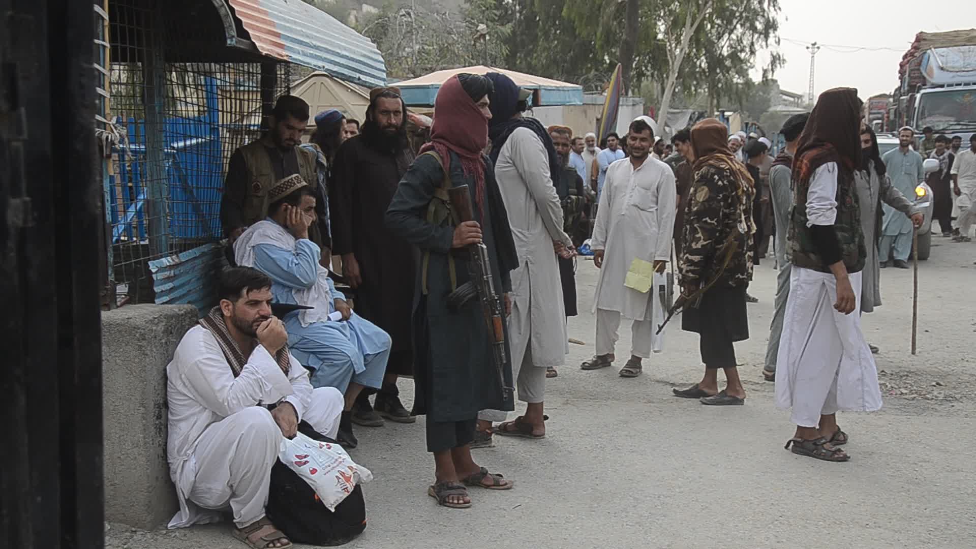 Taliban fighters and Pakistani soldiers guard the Torkham crossing side-by-side in Peshawar