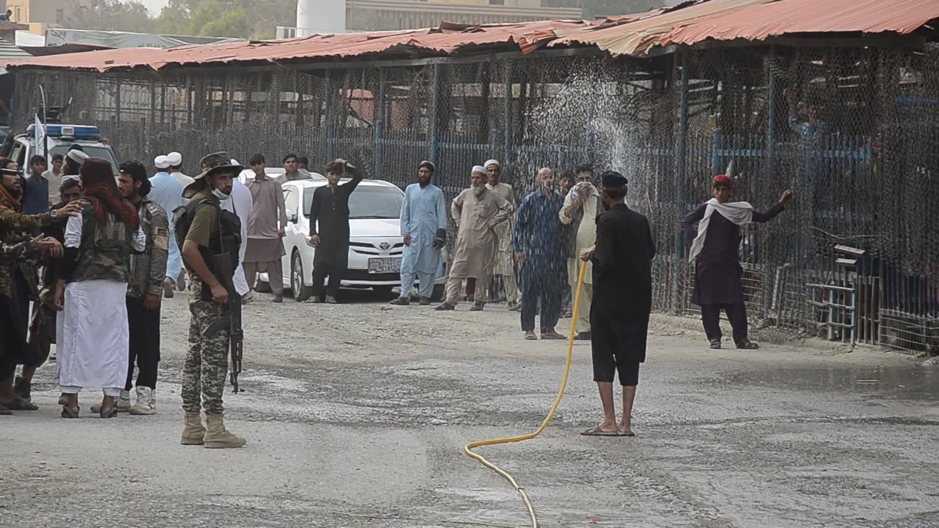 Taliban fighters and Pakistani soldiers guard the Torkham crossing side-by-side in Peshawar