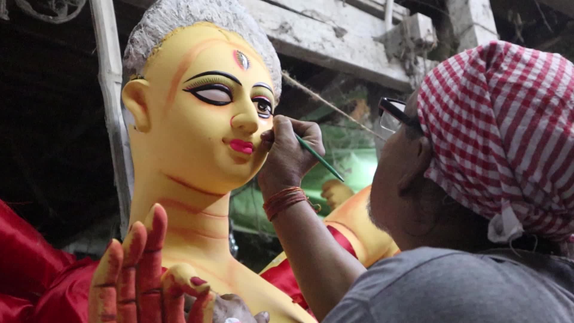 An artist creates eyes of Hindu Goddess Durga 