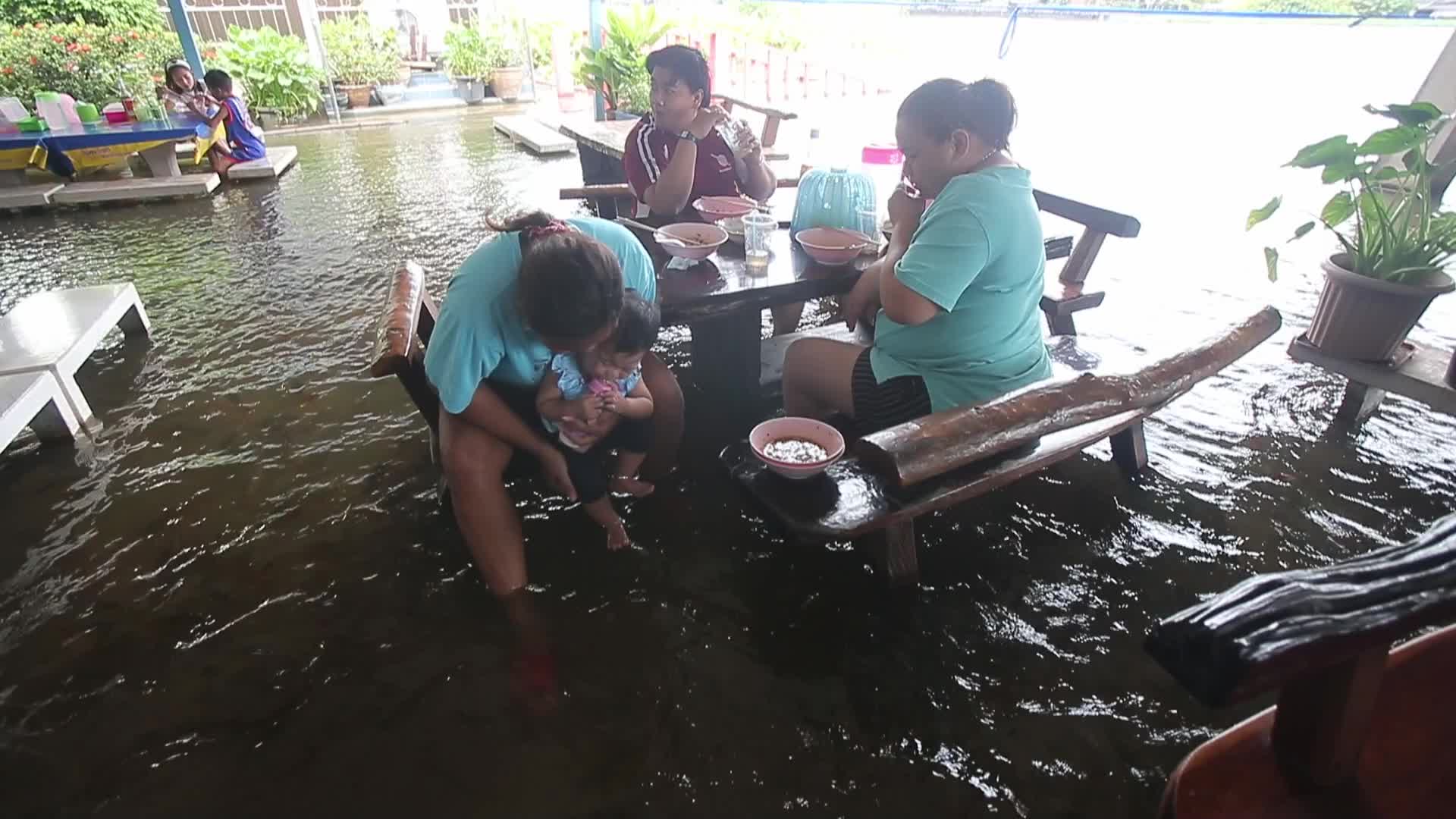 Water overflows from the Tha Chin river in a flooded-noodle shop