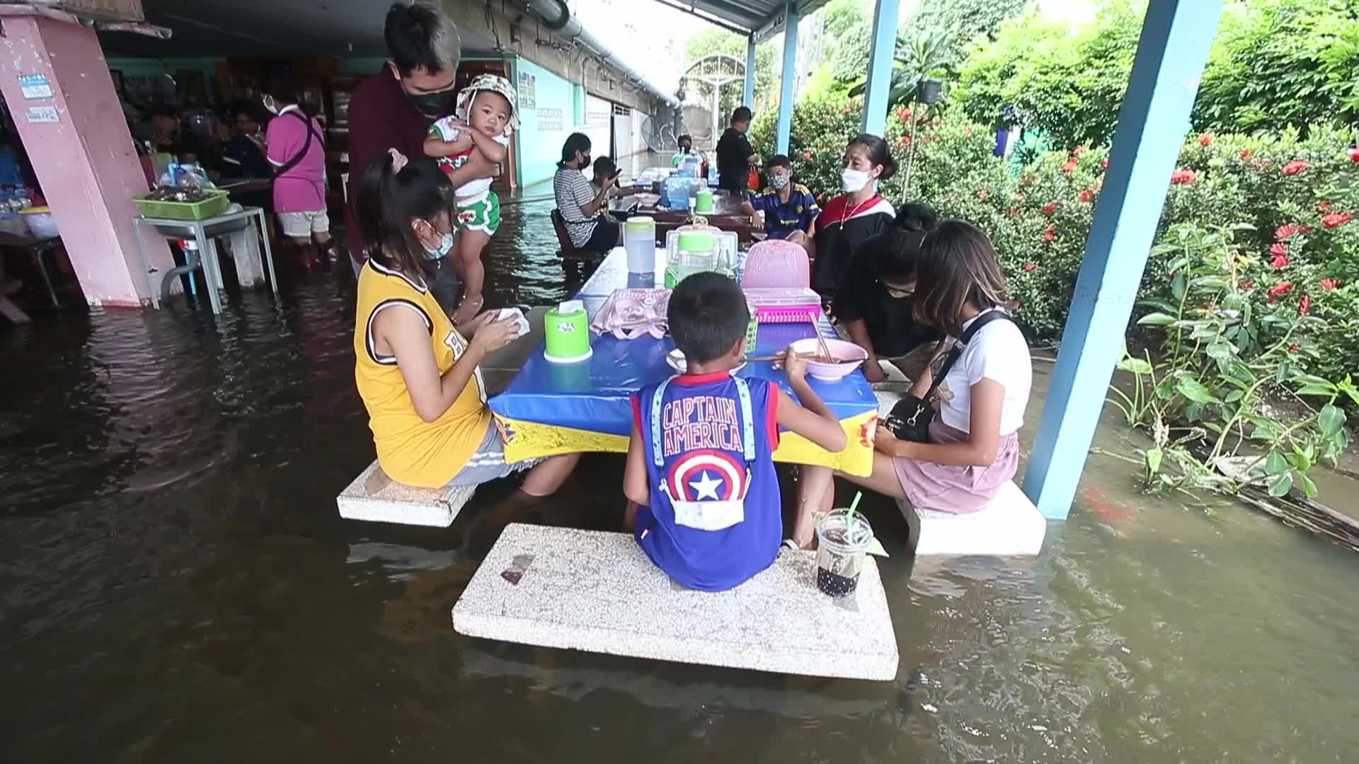 Water overflows from the Tha Chin river in a flooded-noodle shop