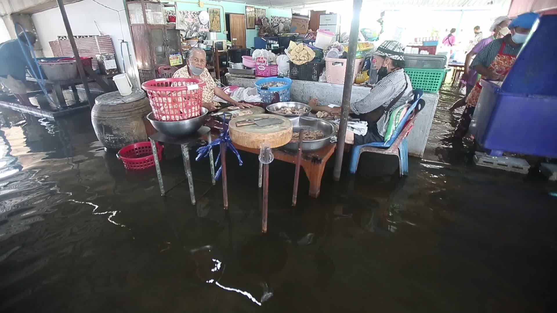 Water overflows from the Tha Chin river in a flooded-noodle shop