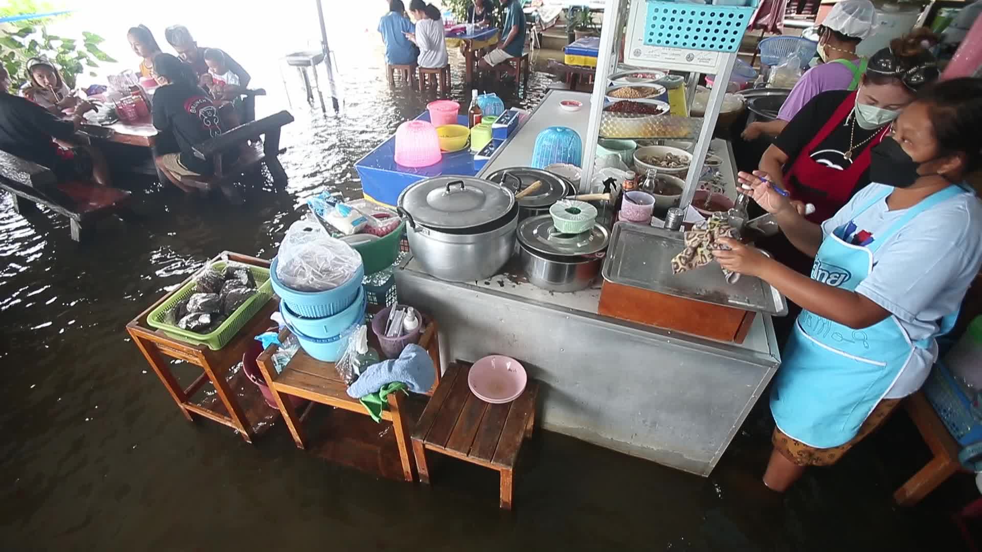 Water overflows from the Tha Chin river in a flooded-noodle shop
