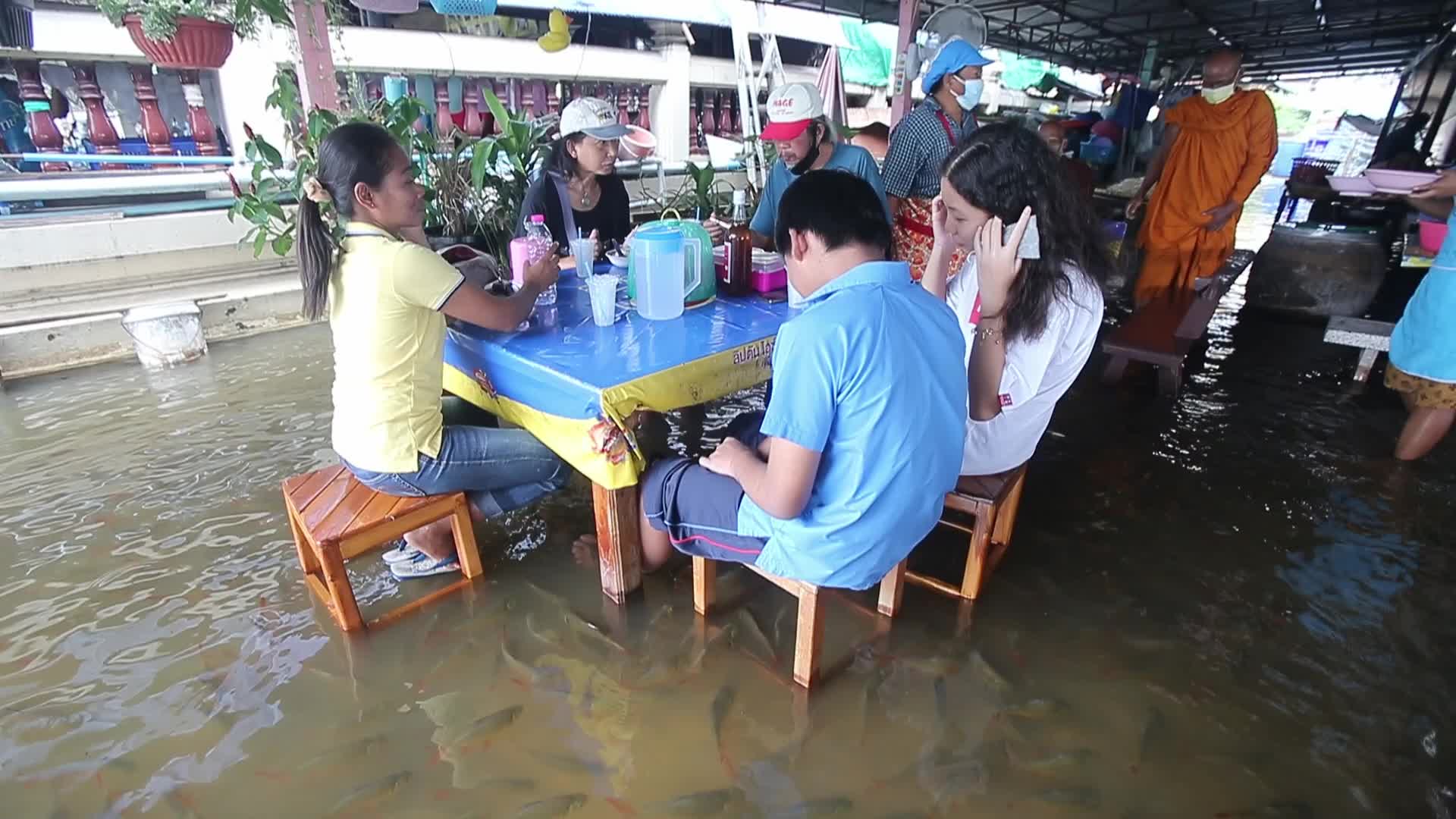Water overflows from the Tha Chin river in a flooded-noodle shop
