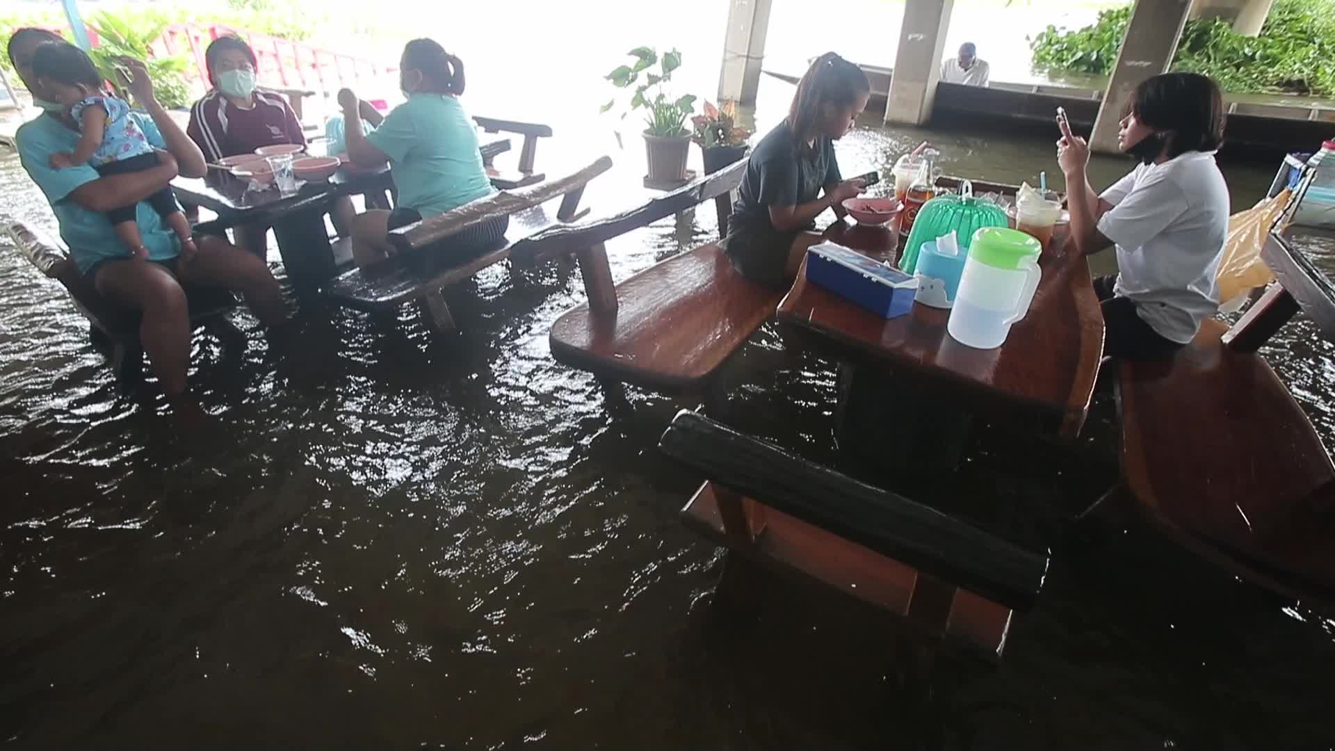 Water overflows from the Tha Chin river in a flooded-noodle shop