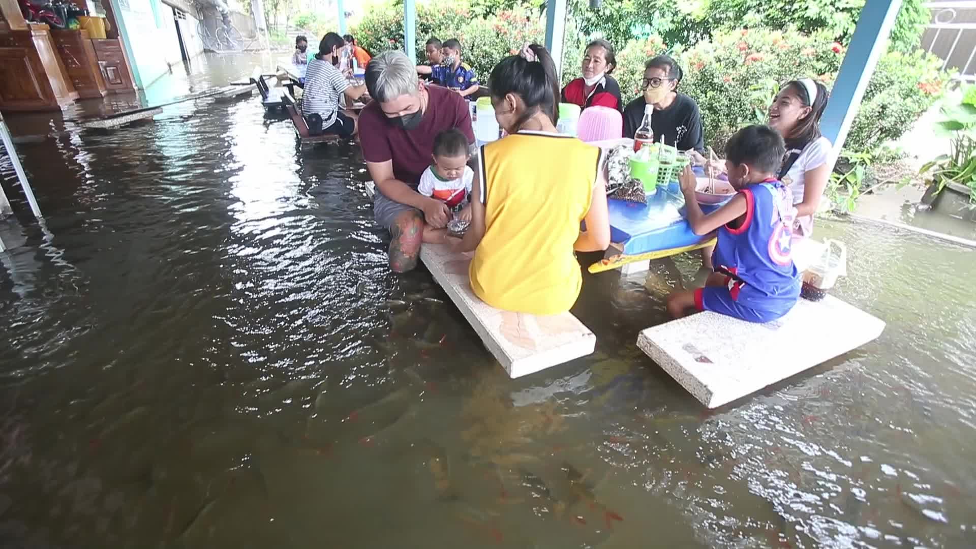Water overflows from the Tha Chin river in a flooded-noodle shop