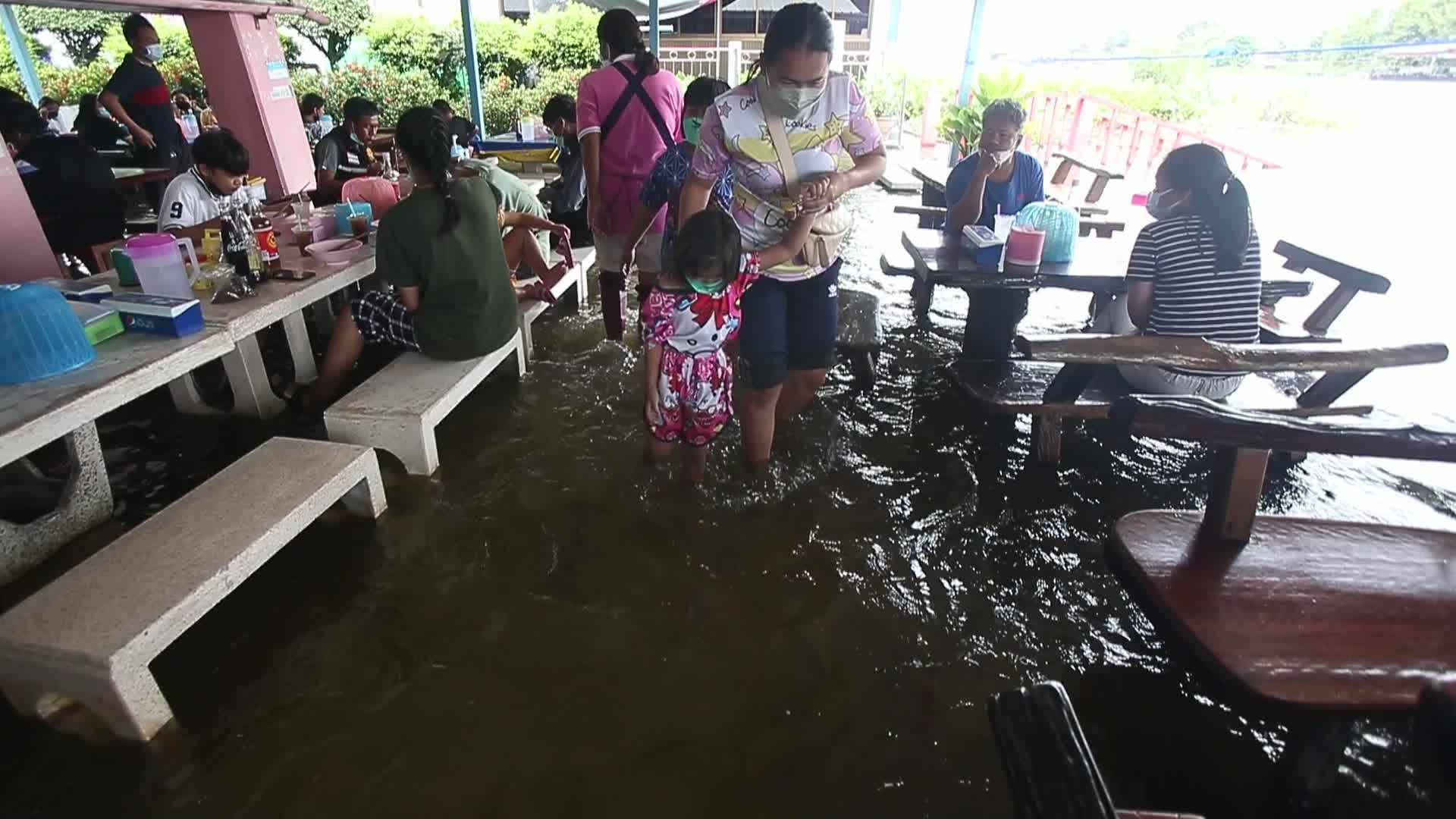 Water overflows from the Tha Chin river in a flooded-noodle shop