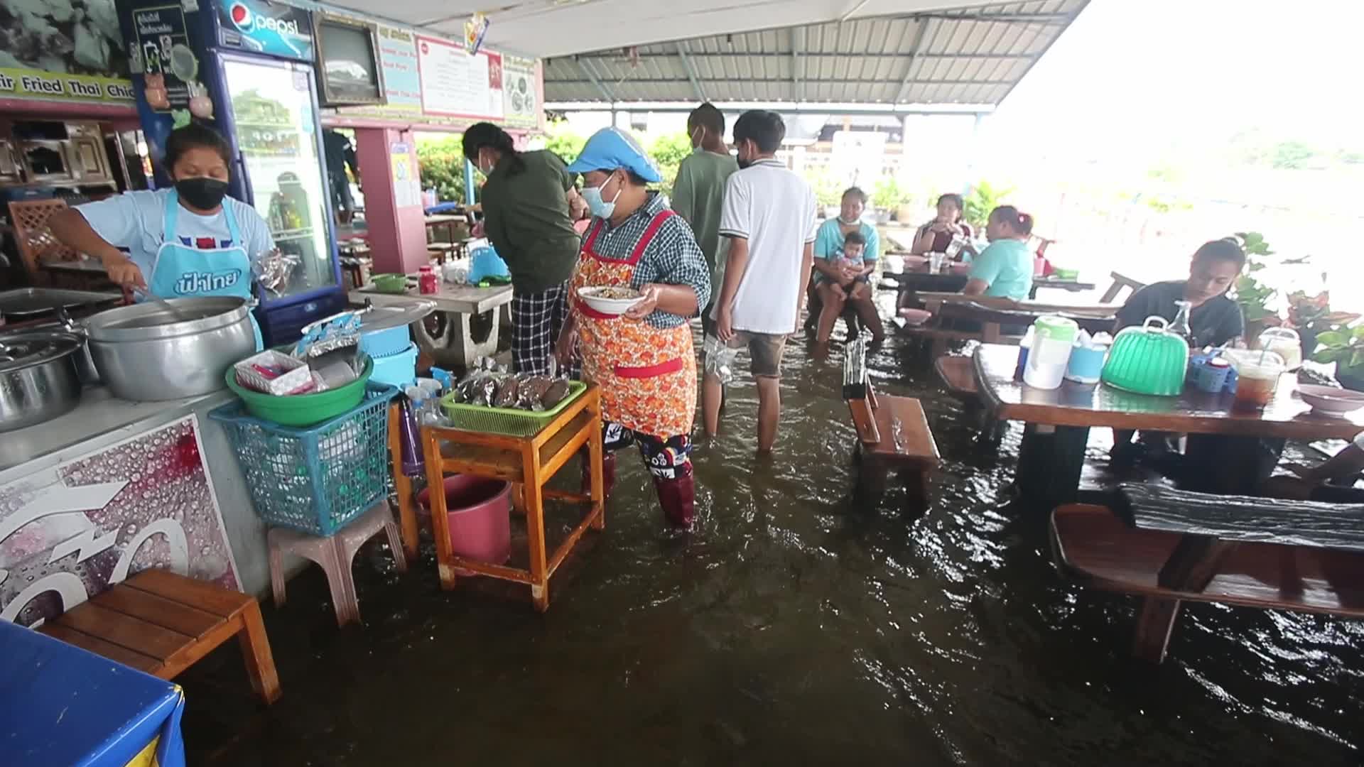 Water overflows from the Tha Chin river in a flooded-noodle shop