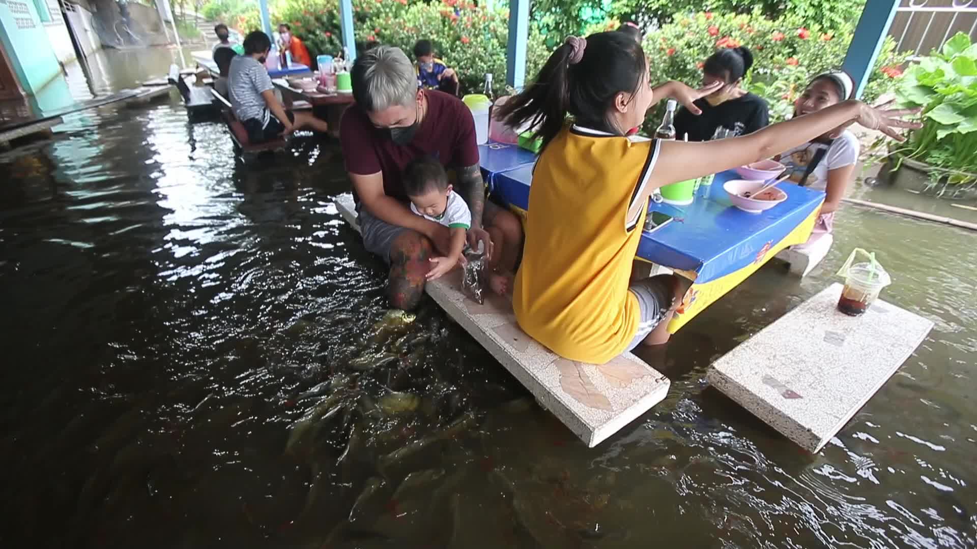 Water overflows from the Tha Chin river in a flooded-noodle shop