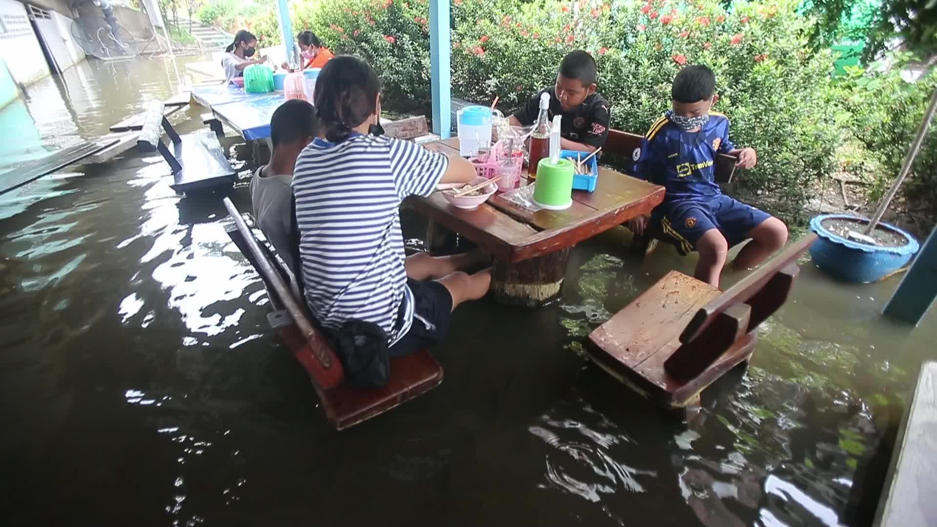 Water overflows from the Tha Chin river in a flooded-noodle shop