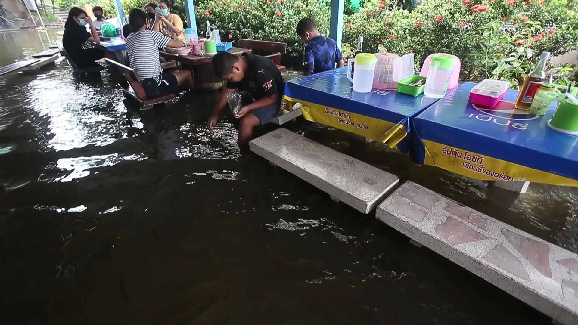 Water overflows from the Tha Chin river in a flooded-noodle shop
