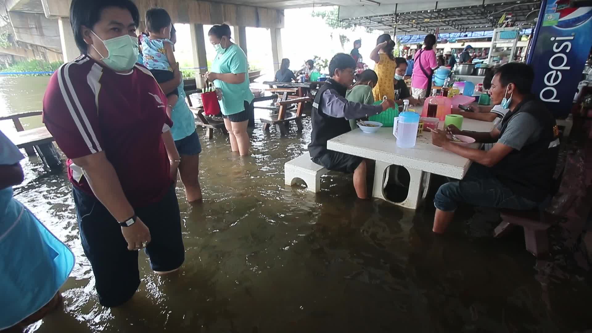 Water overflows from the Tha Chin river in a flooded-noodle shop
