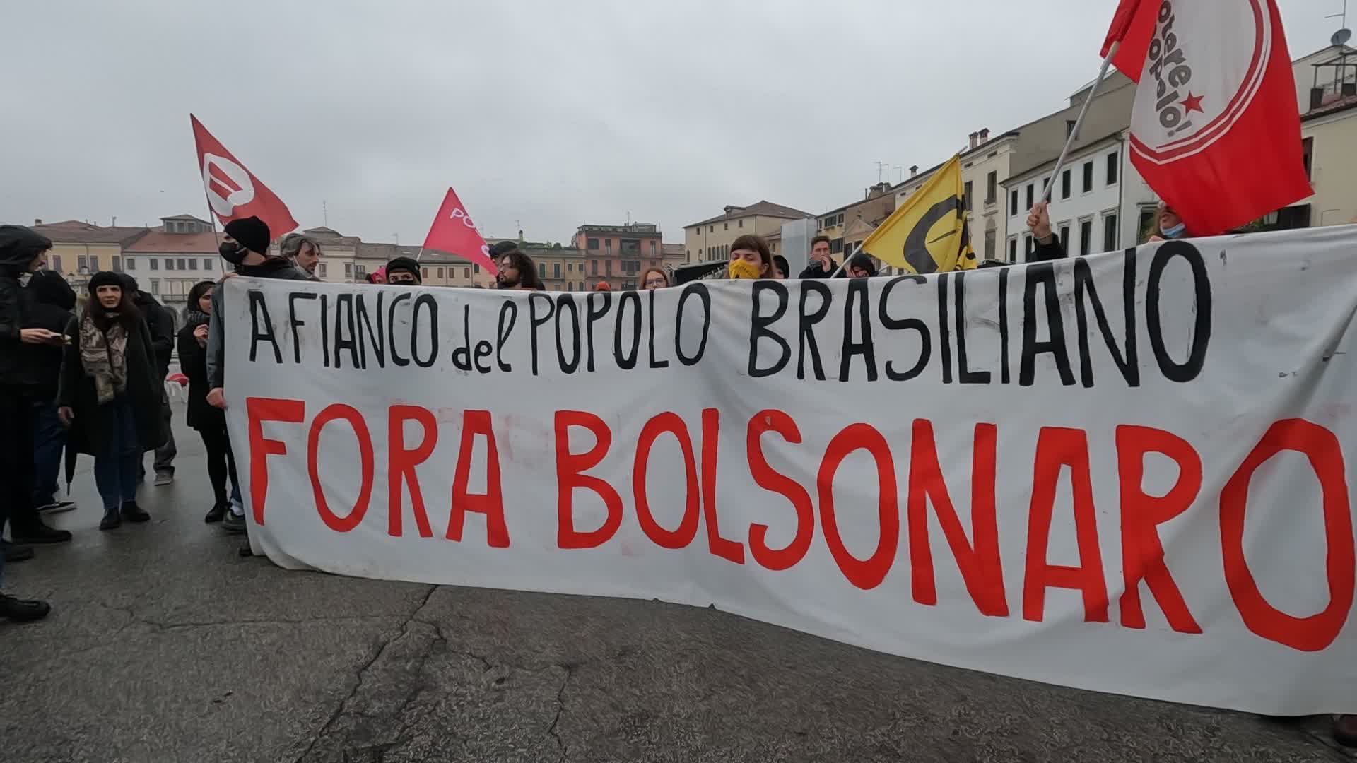 Protesters parade with a banner against Jair Bolsonaro