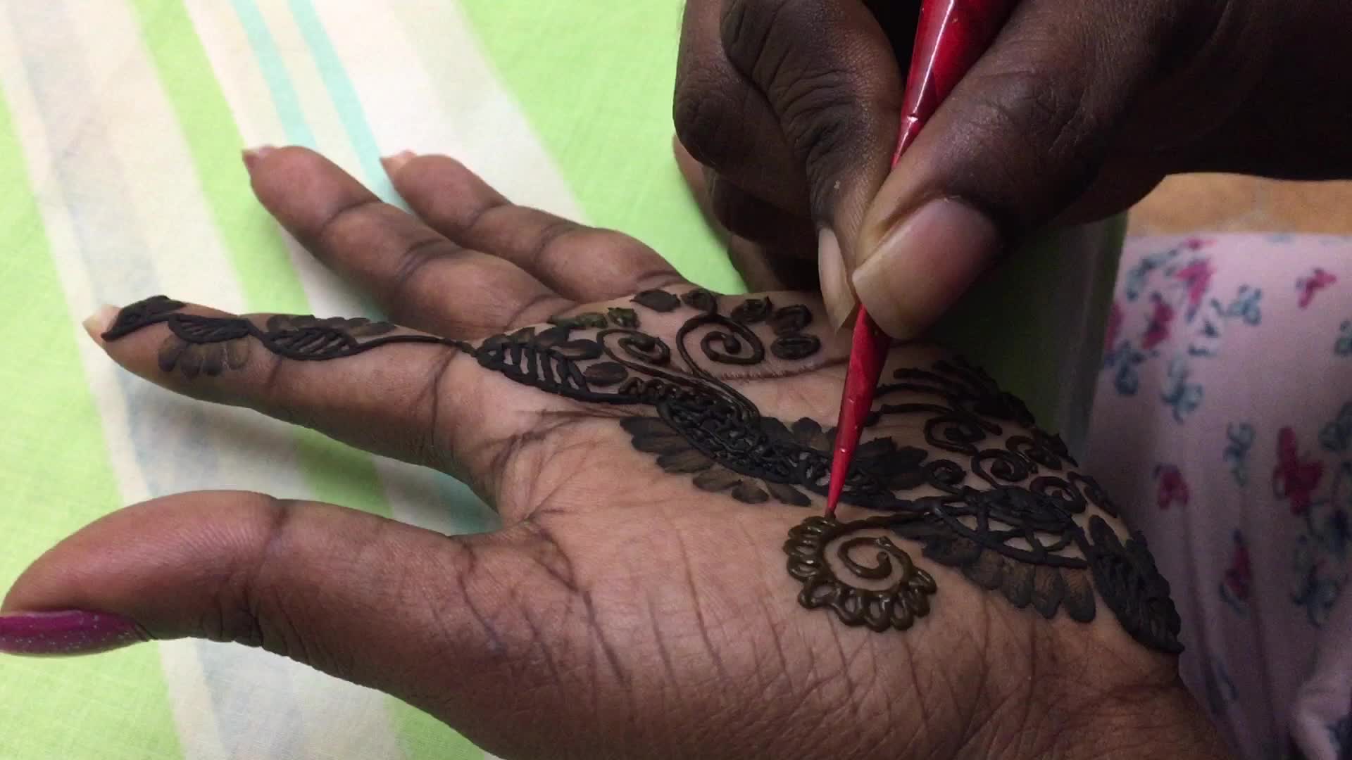 Henna is applied to the hands of a Hindu woman during Diwali