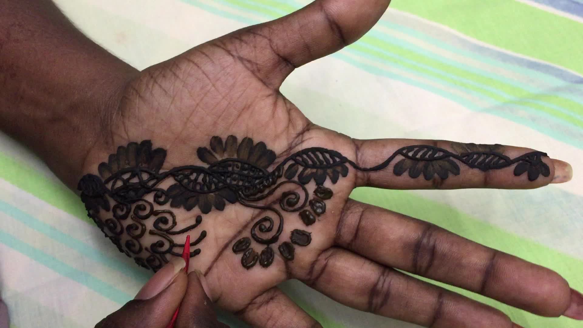 Henna is applied to the hands of a Hindu woman during Diwali