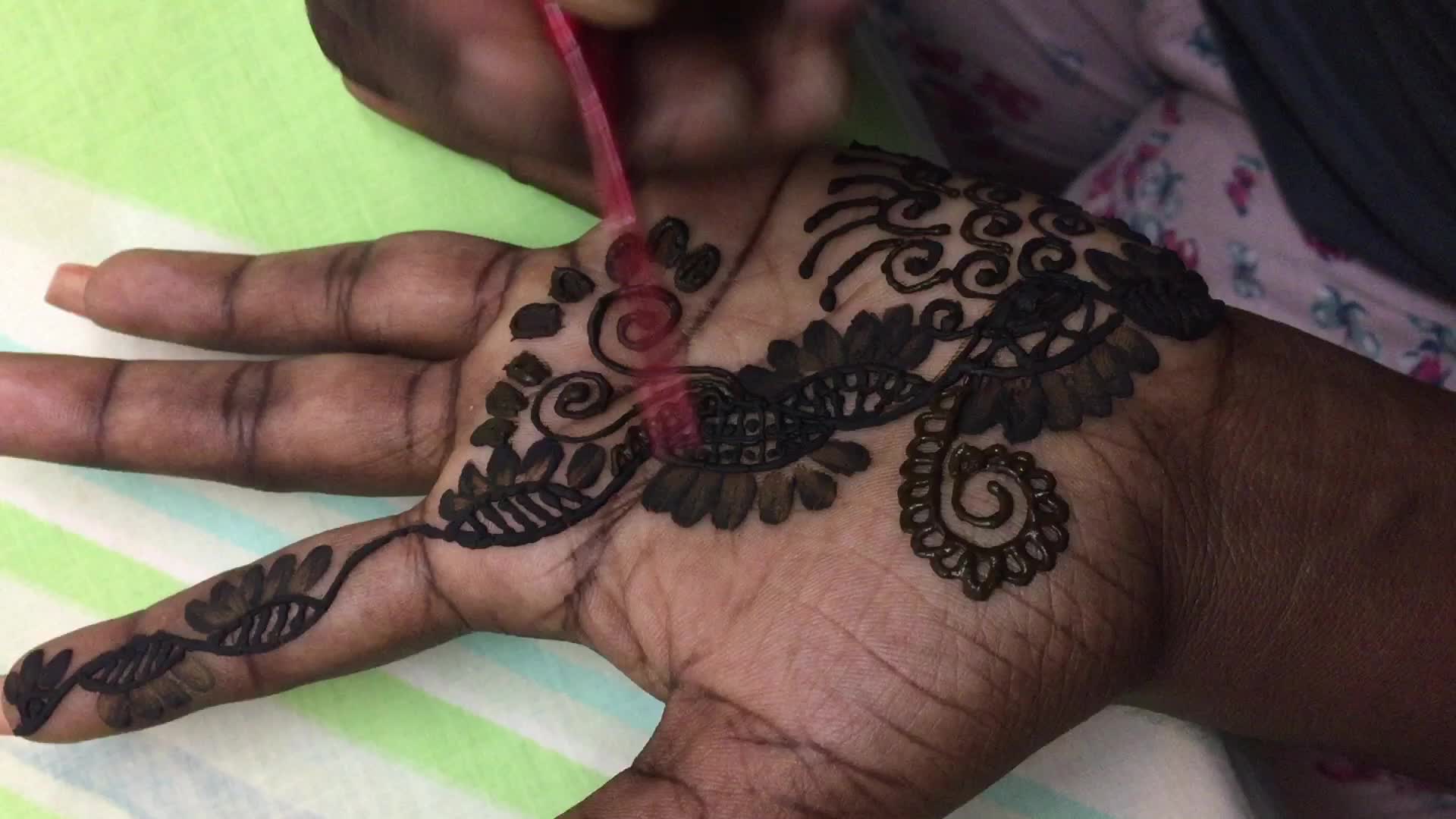 Henna is applied to the hands of a Hindu woman during Diwali