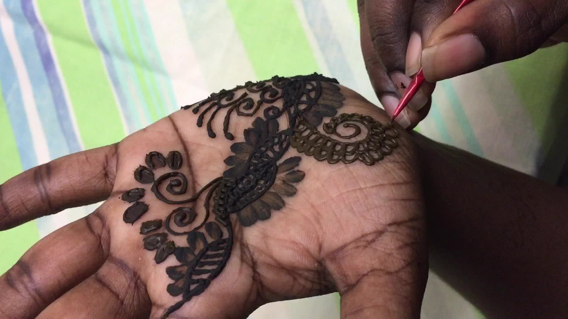 Henna is applied to the hands of a Hindu woman during Diwali