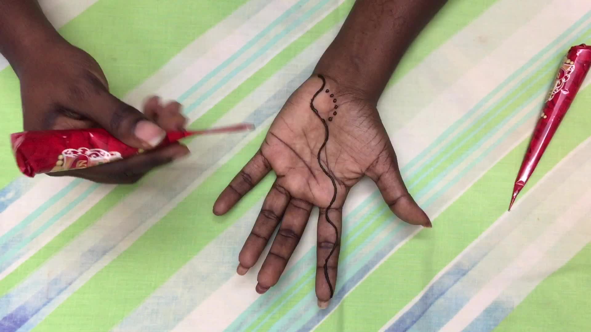 Henna is applied to the hands of a Hindu woman during Diwali