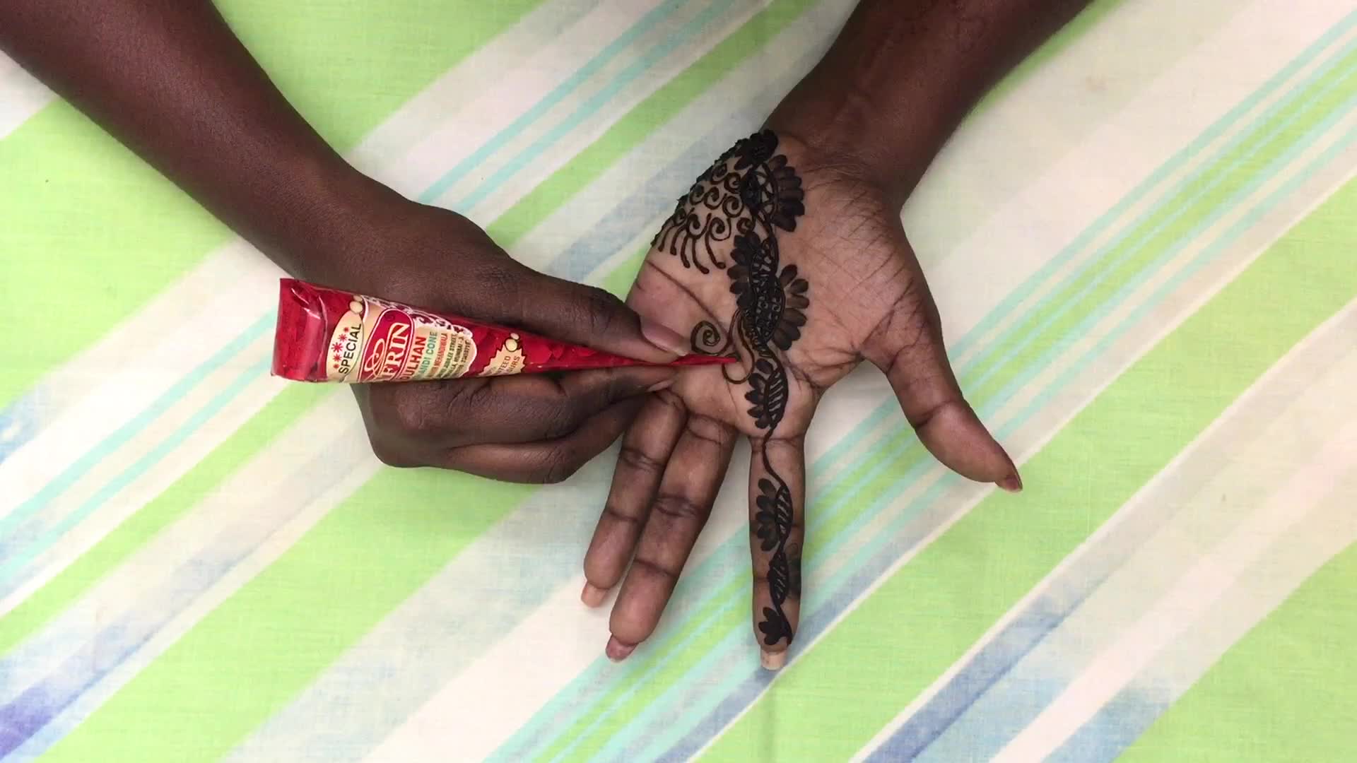 Henna is applied to the hands of a Hindu woman during Diwali